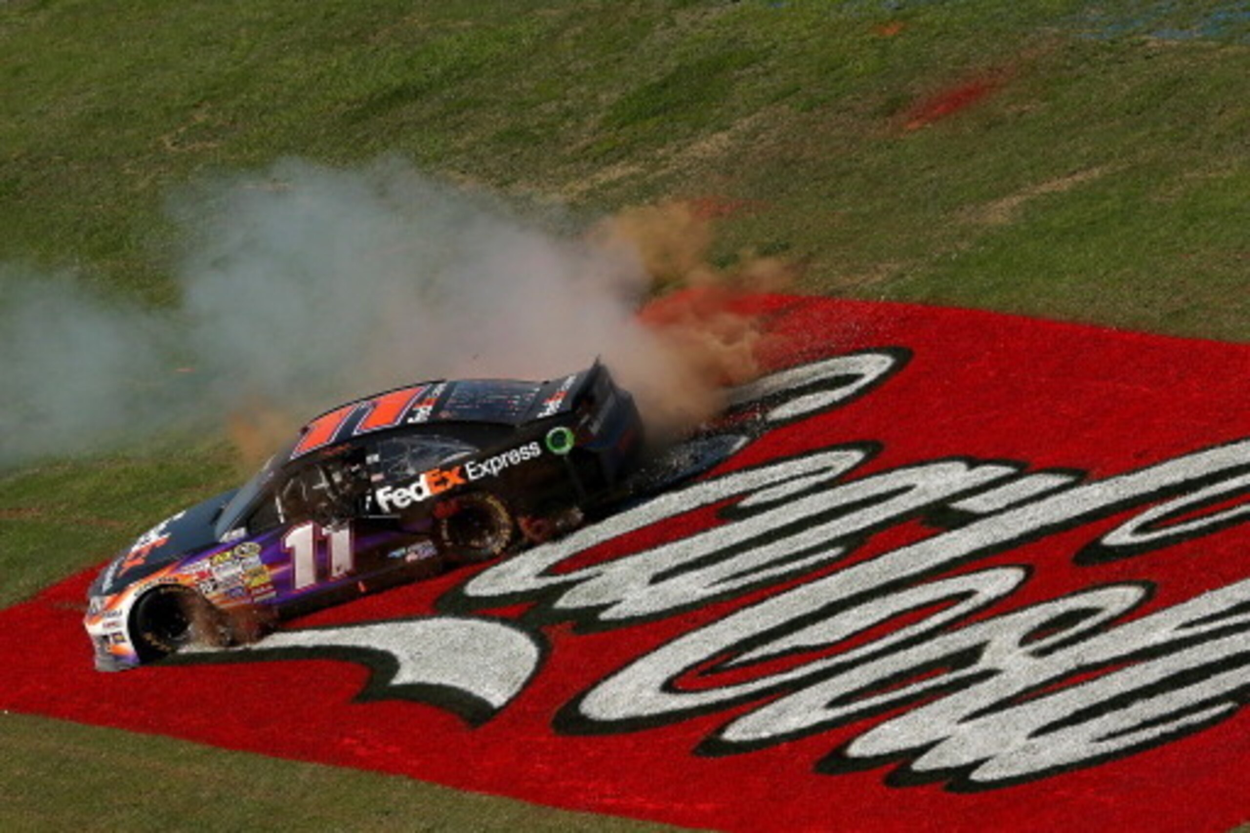 TALLADEGA, AL - MAY 04:  Denny Hamlin, driver of the #11 FedEx Express Toyota, celebrates with a burnout after winning the NASCAR Sprint Cup Series Aaron's 499 at Talladega Superspeedway on May 4, 2014 in Talladega, Alabama.  (Photo by Mike Ehrmann/Getty 