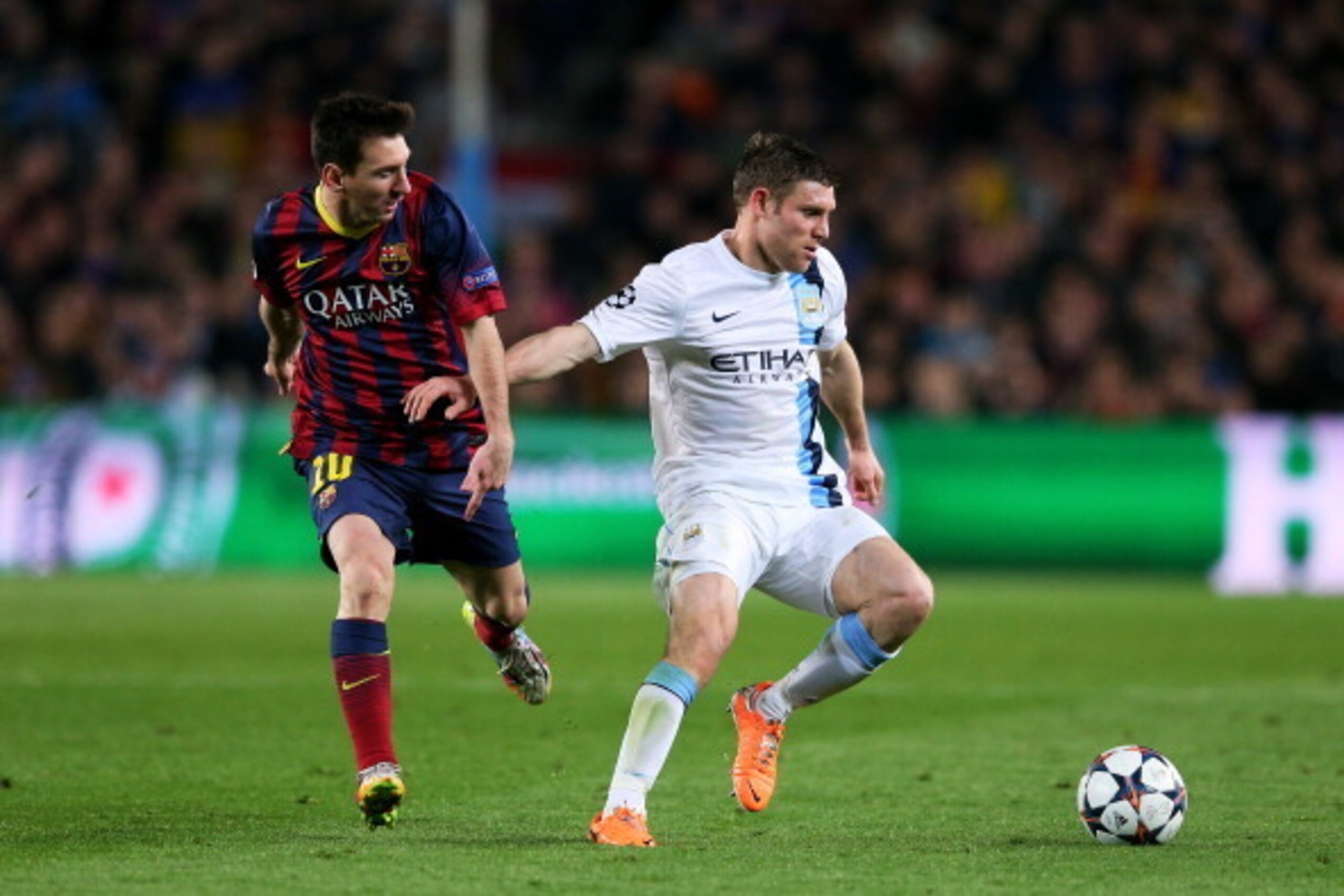 BARCELONA, SPAIN - MARCH 12:  James Milner of Manchester City holds off Lionel Messi of Barcelona during the UEFA Champions League Round of 16, second leg match between FC Barcelona and Manchester City  at Camp Nou on March 12, 2014 in Barcelona, Spain.  