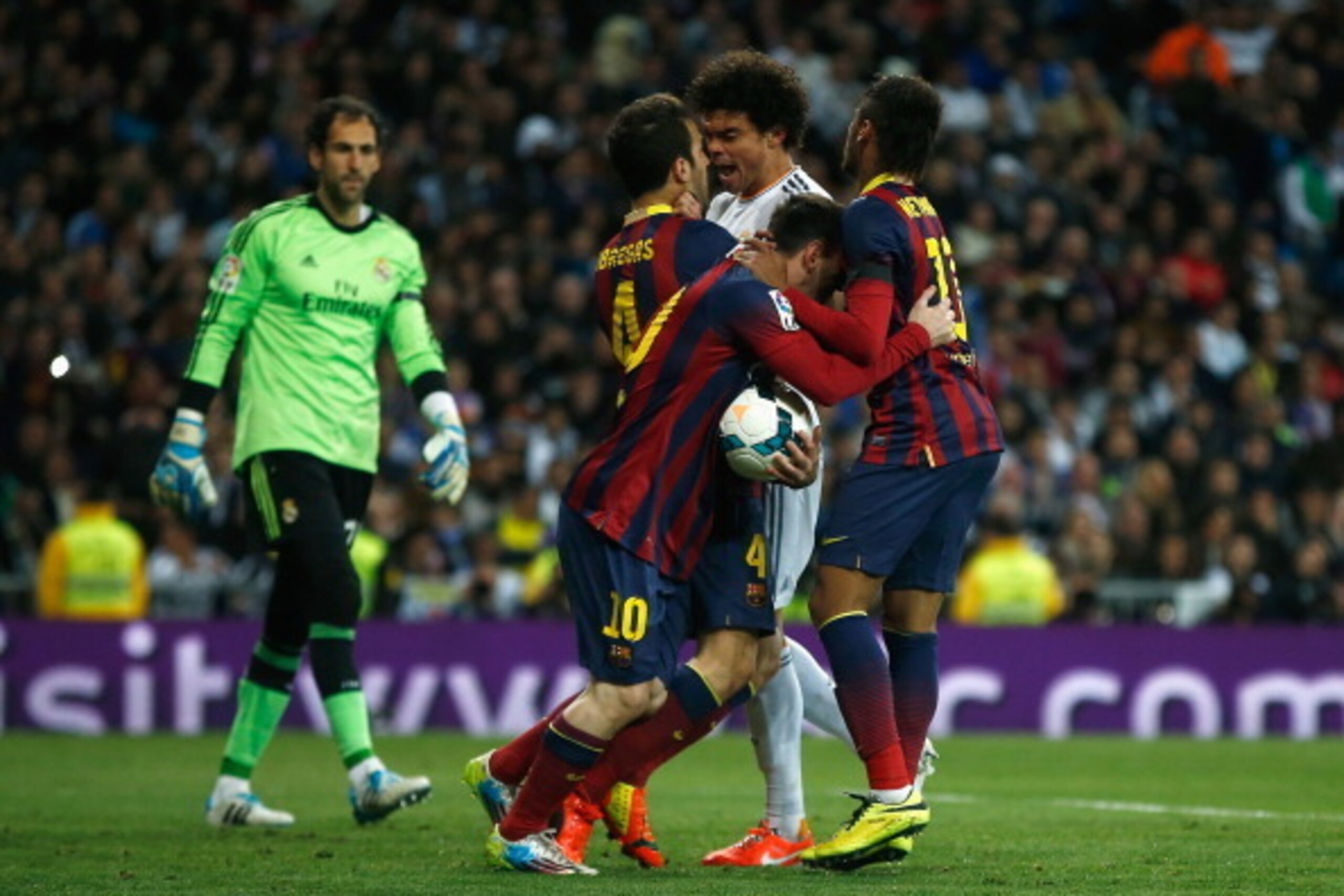 MADRID, SPAIN - MARCH 23:  Lionel Messi of Barcelona collects the ball after scoring his goal as Pepe of Real Madrid confronts Cesc Fabregas of Barcelona during the La Liga match between Real Madrid CF and FC Barcelona at the Bernabeu on March 23, 2014 in
