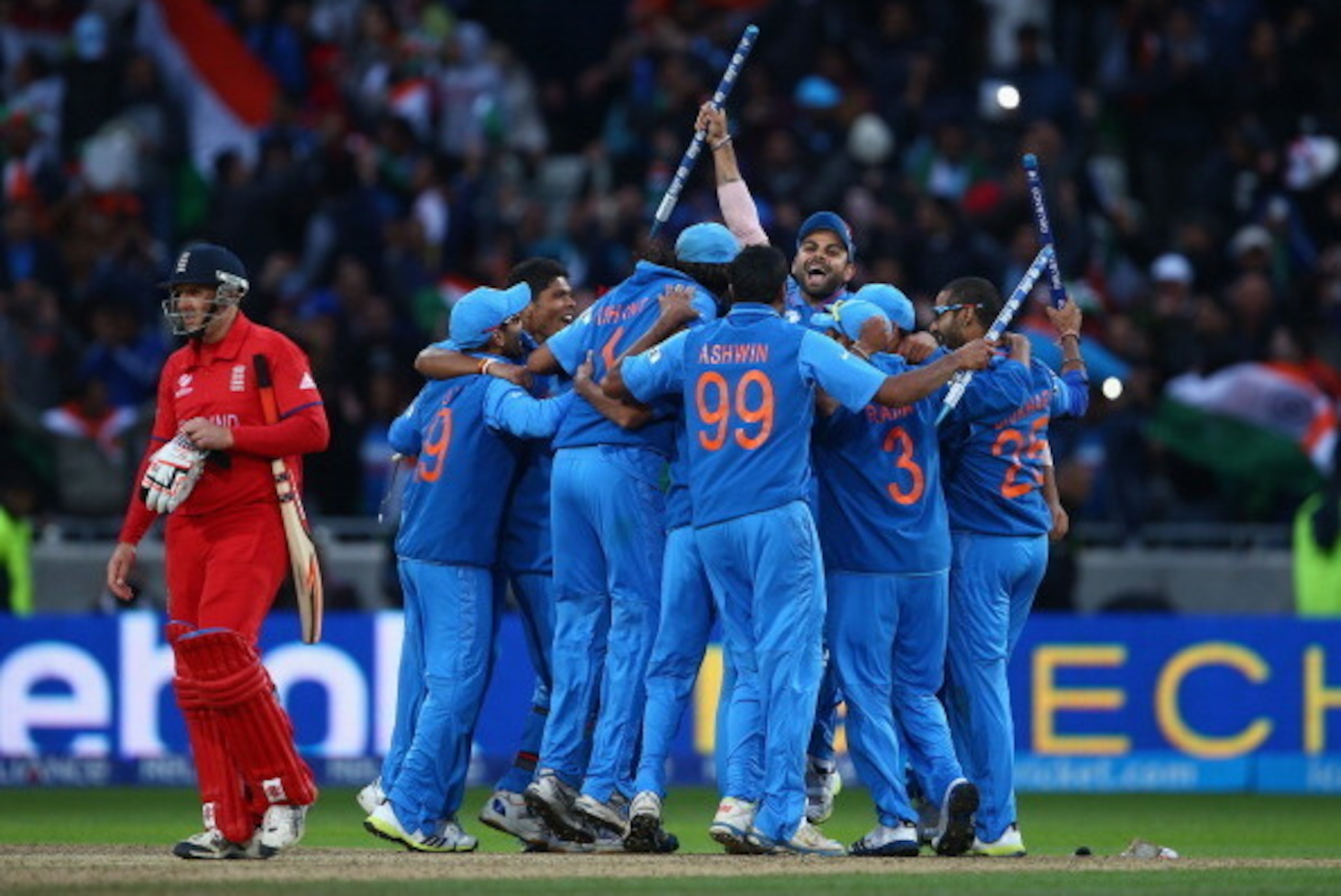BIRMINGHAM, ENGLAND - JUNE 23:  The India team celebrate as James Tredwell of England looks dejected after India won the ICC Champions Trophy Final match between England and India at Edgbaston on June 23, 2013 in Birmingham, England.  (Photo by Paul Gilha