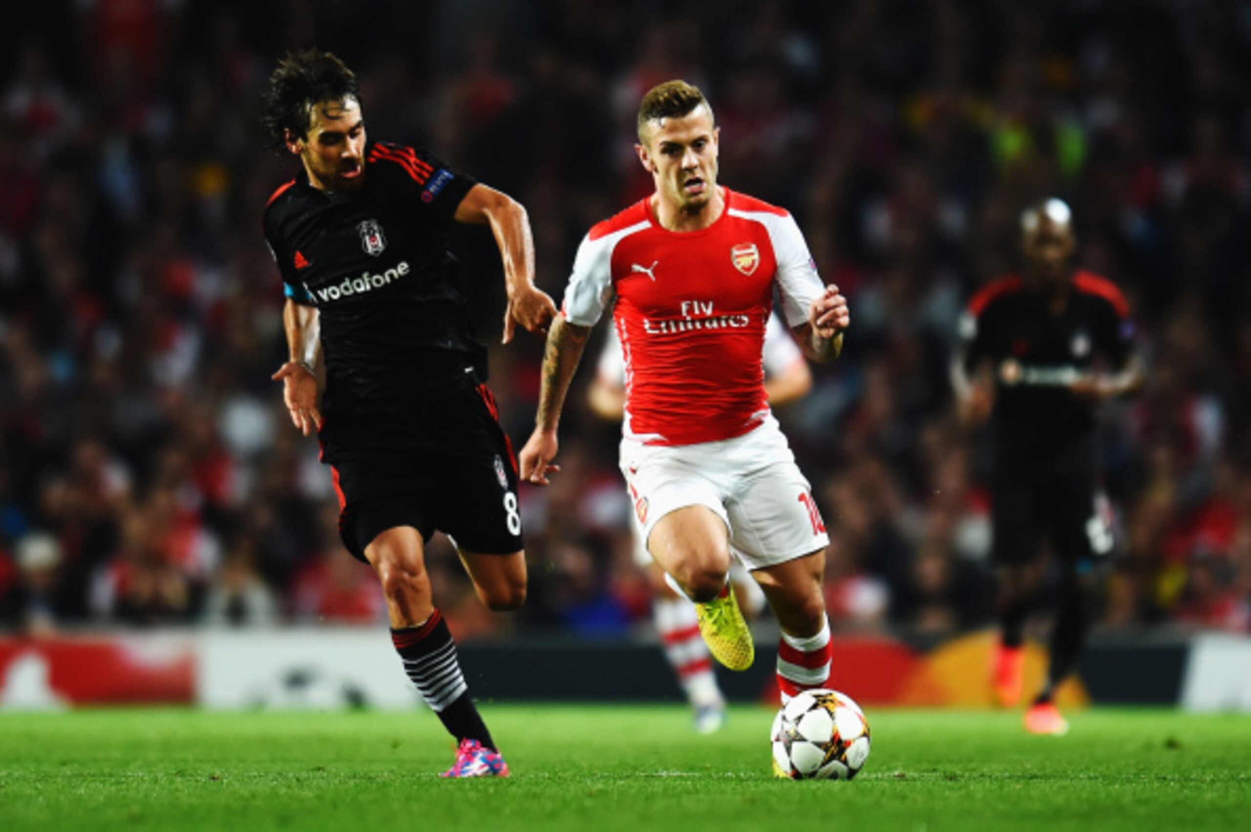 LONDON, ENGLAND - AUGUST 27:  Jack Wilshere (R) of Arsenal holds off the challenge of Veli Kavlak of Besiktas during the UEFA Champions League Qualifier 2nd leg match between Arsenal and Besiktas at the Emirates Stadium on August 27, 2014 in London, Unite