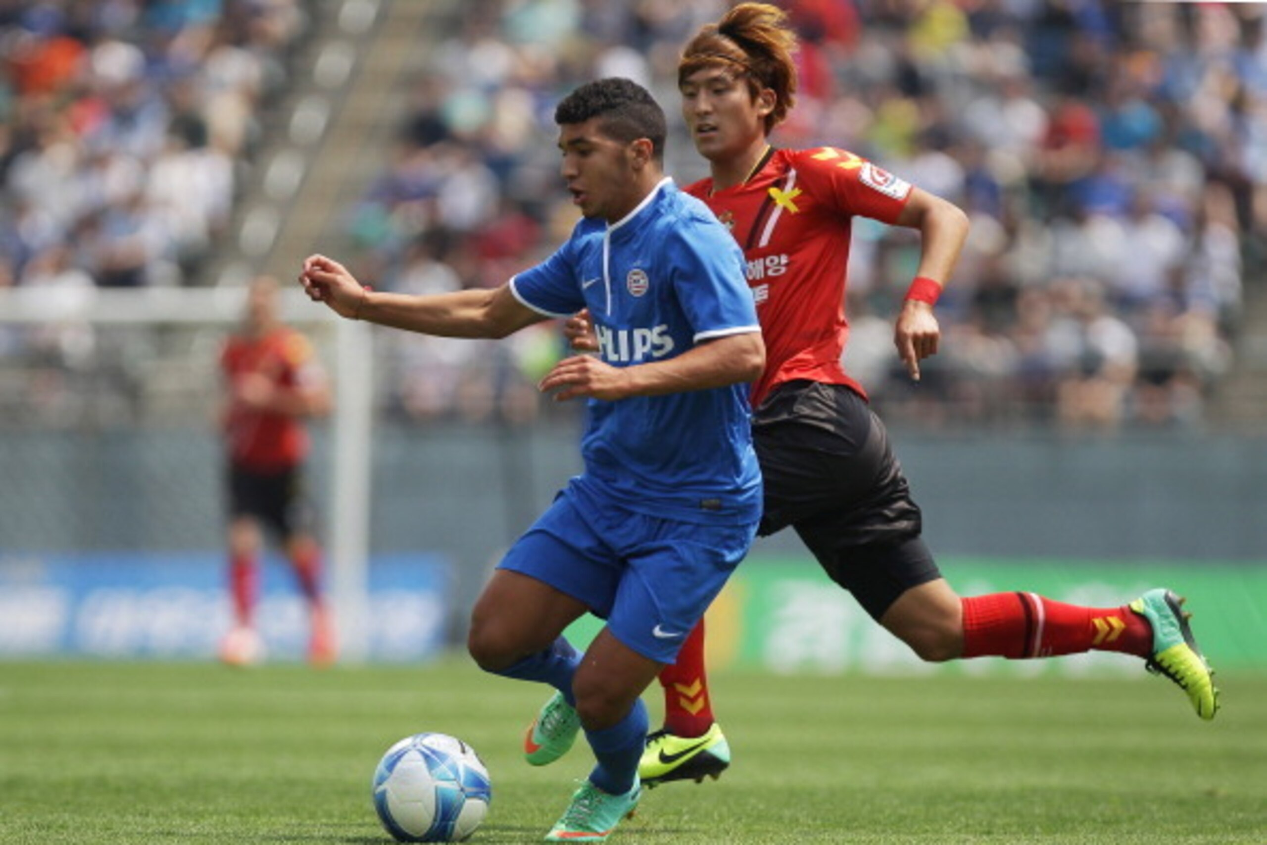 CHANGWON, SOUTH KOREA - MAY 24:  Zakaria Bakkali of PSV Eindhoven compete for the ball with Lee Han-Sam of Gyeongnam FC during the friendly match between PSV Eindhoven and Gyeongnam FC at Changwon Stadium on May 24, 2014 in Changwon, South Korea.  (Photo 