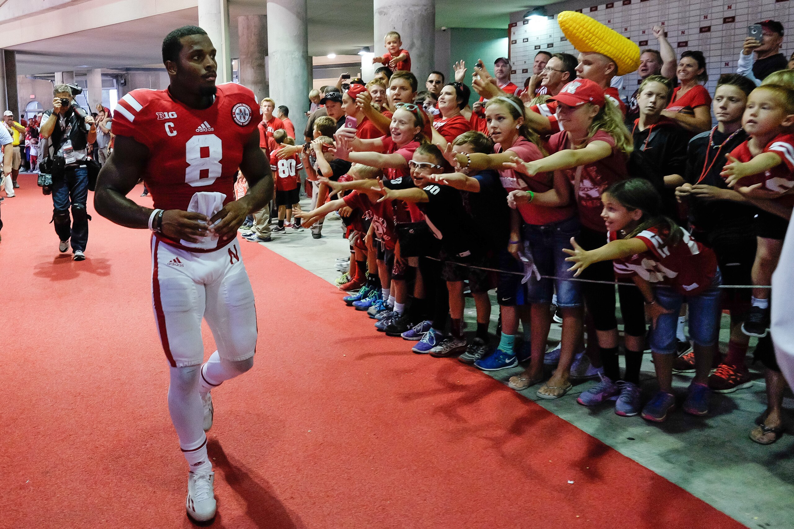LINCOLN, NE - SEPTEMPER 6: Running back Ameer Abdullah #8 of the Nebraska Cornhuskers hands out pieces of his uniform after their game against the McNeese State Cowboys at Memorial Stadium on September 6, 2014 in Lincoln, Nebraska. Nebraska defeated McNee