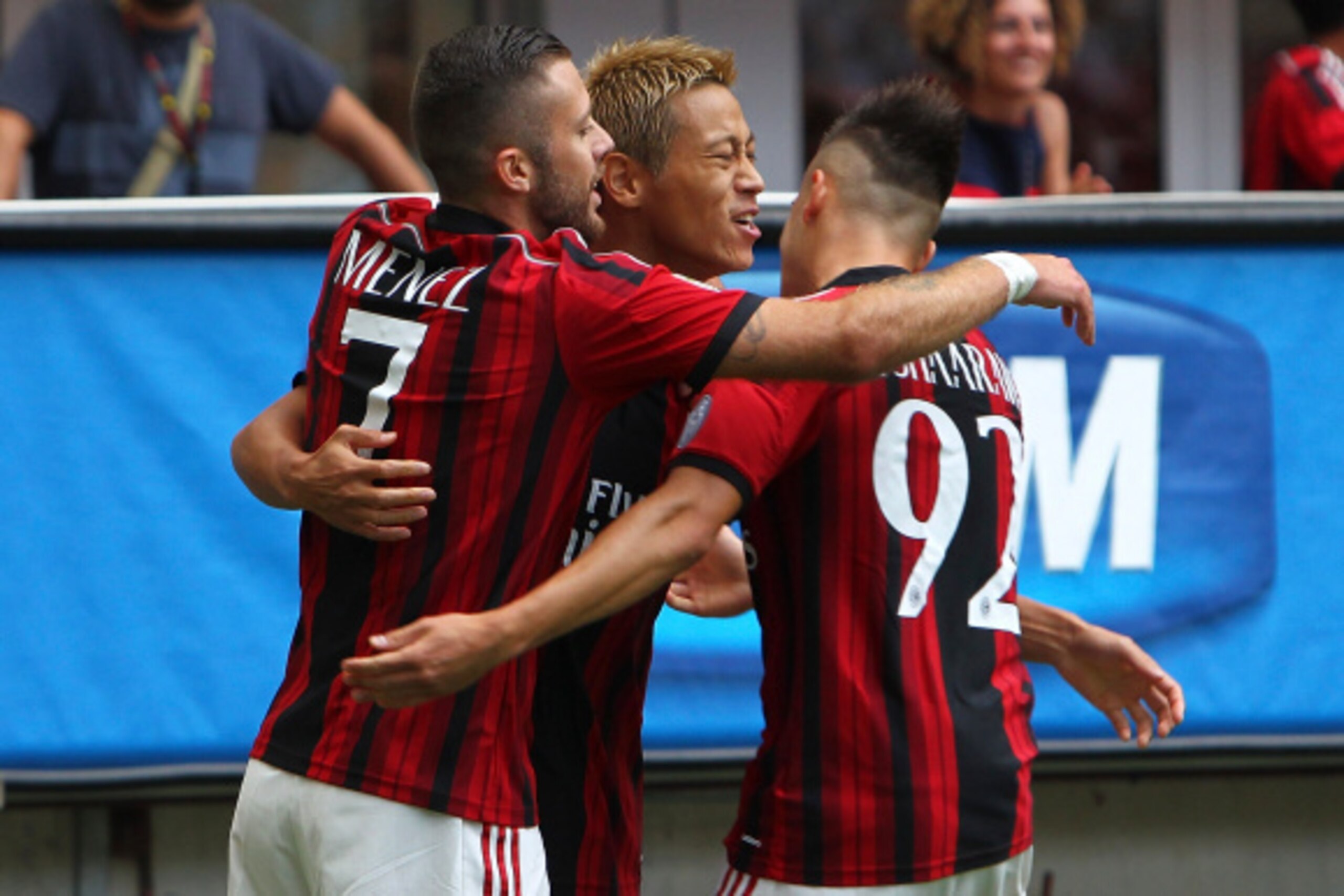MILAN, ITALY - AUGUST 31:  Keisuke Honda of AC Milan celebrates with his team-mates Jeremy Menez (L) and Stephan El Shaarawy (R) after scoring the opening goal during the Serie A match between AC Milan and SS Lazio at Stadio Giuseppe Meazza on August 31,