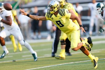 EUGENE, OR - SEPTEMBER 6: Marcus Mariota #8 of the Oregon Ducks throws the ball while under pressure during the game against the Michigan State Spartans at Autzen Stadium on September 6, 2014 in Eugene, Oregon. Oregon won 46-27. (Photo by Joe Robbins/Gett