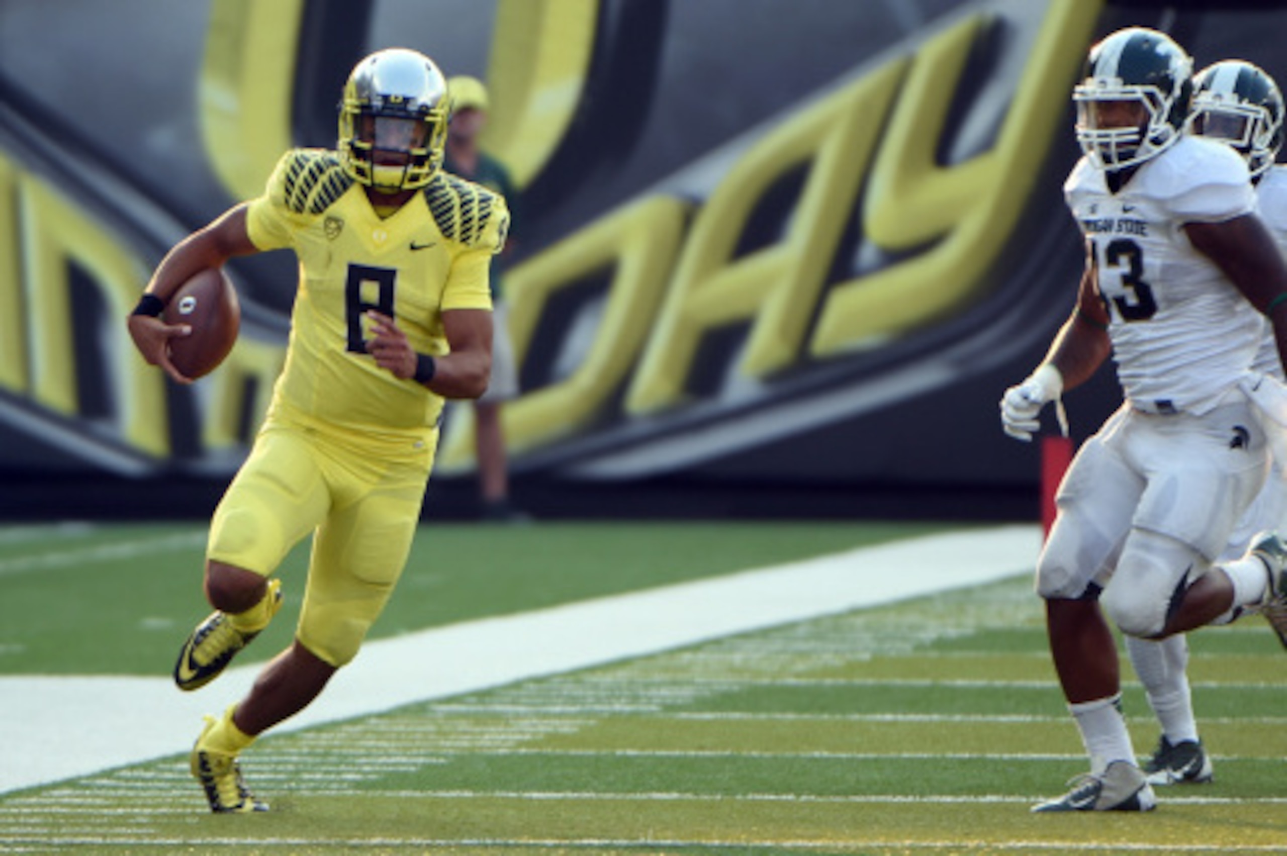 EUGENE, OR -SEPTEMBER 06: Quarterback Marcus Mariota #8 of the Oregon Ducks runs with the ball as linebacker Ed Davis #43 of the Michigan State Spartans gives chase during the third quarter of the game at Autzen Stadium on September 6, 2014 in Eugene, Ore