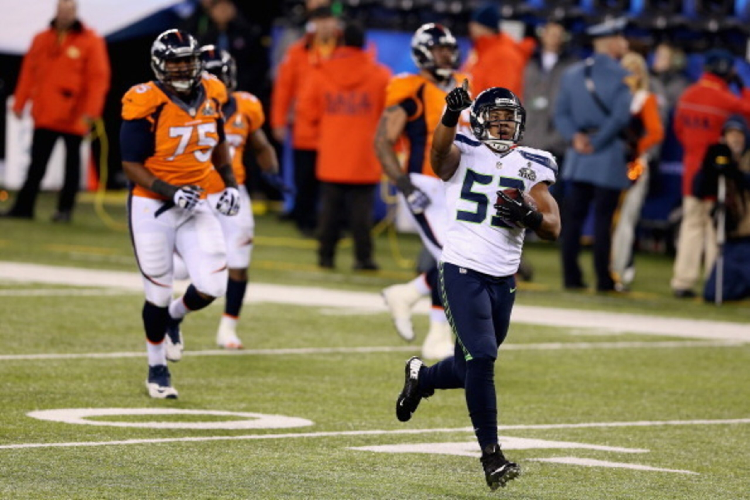 EAST RUTHERFORD, NJ - FEBRUARY 02:  Outside linebacker Malcolm Smith #53 of the Seattle Seahawks runs back an interception for 69 yards off quarterback Peyton Manning of the Denver Broncos during the second quarter of Super Bowl XLVIII at MetLife Stadium 