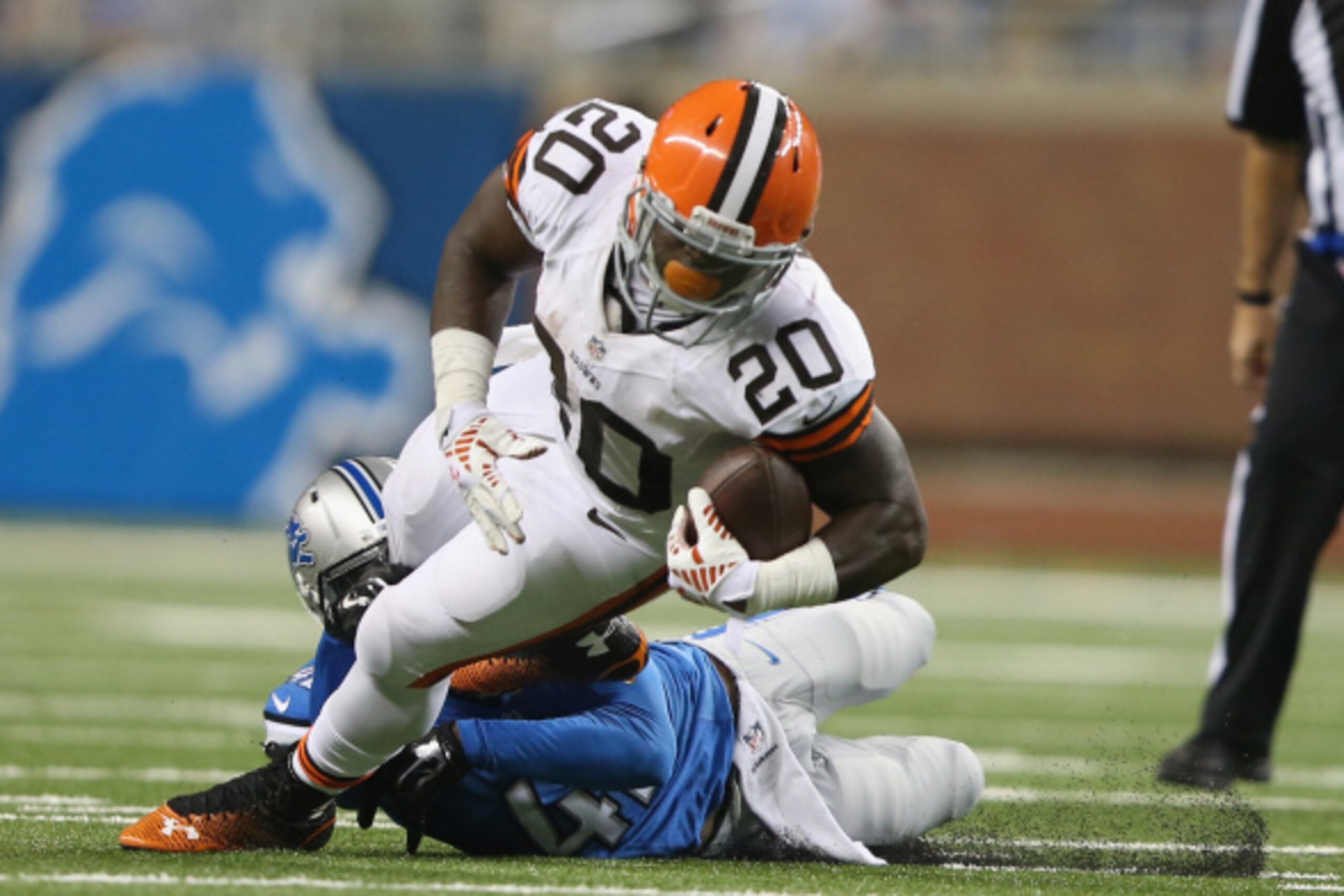 DETROIT, MI - AUGUST 09: Terrance West #20 of the Cleveland Browns tries to get out of the tackle by Isa Abdul-Quddus #42 of the Detroit Lions in the third quarter during a preseason game at Ford Field on August 9, 2014 in Detroit, Michigan. (Photo by Leo