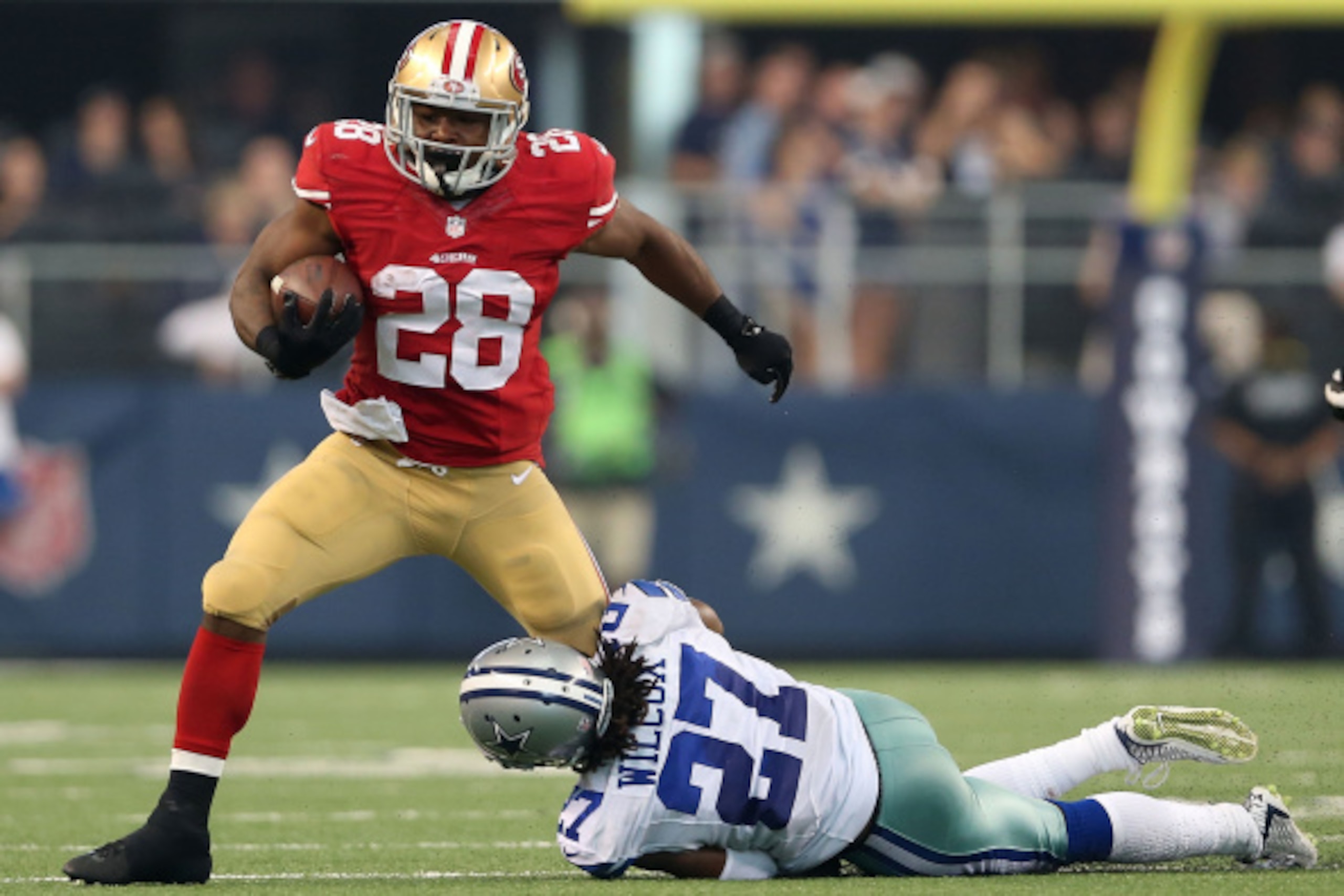 ARLINGTON, TX - SEPTEMBER 07: Carlos Hyde #28 of the San Francisco 49ers tries to break from the grasp of J.J. Wilcox #27 of the Dallas Cowboys in the second half at AT&T Stadium on September 7, 2014 in Arlington, Texas. (Photo by Christian Petersen/Getty