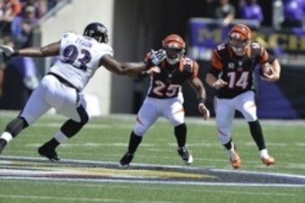 Sep 7, 2014; Baltimore, MD, USA; Cincinnati Bengals quarterback Andy Dalton (14) runs with the ball as  running back Giovani Bernard (25) blocks Baltimore Ravens defensive end DeAngelo Tyson (93) during the first quarter at M&T Bank Stadium. Mandatory Cre