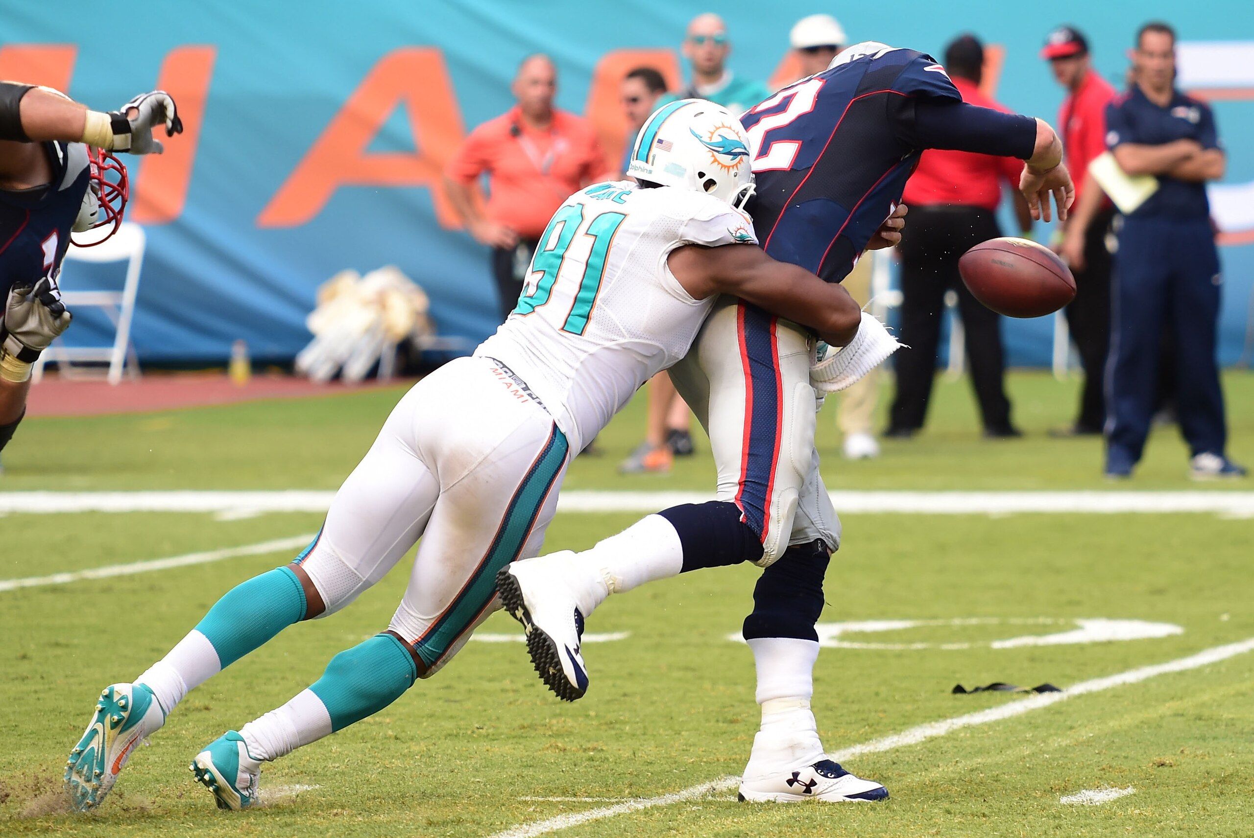 Sep 7, 2014; Miami Gardens, FL, USA;  Miami Dolphins defensive end Cameron Wake (91) hits New England Patriots quarterback Tom Brady (12) in the second half at Sun Life Stadium. Miami won 33-20.  Mandatory Credit: Brad Barr-USA TODAY Sports