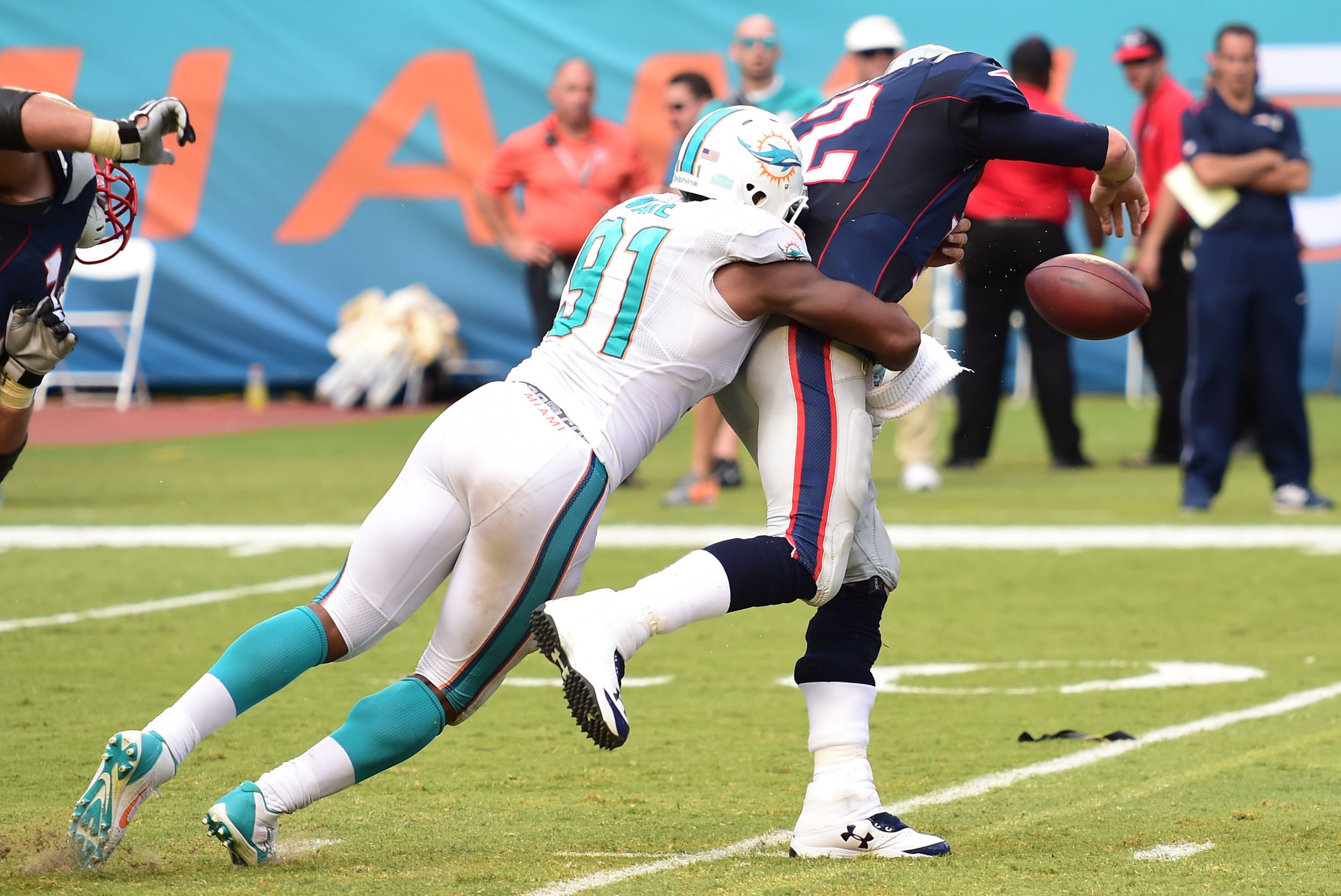 Sep 7, 2014; Miami Gardens, FL, USA;  Miami Dolphins defensive end Cameron Wake (91) hits New England Patriots quarterback Tom Brady (12) in the second half at Sun Life Stadium. Miami won 33-20.  Mandatory Credit: Brad Barr-USA TODAY Sports
