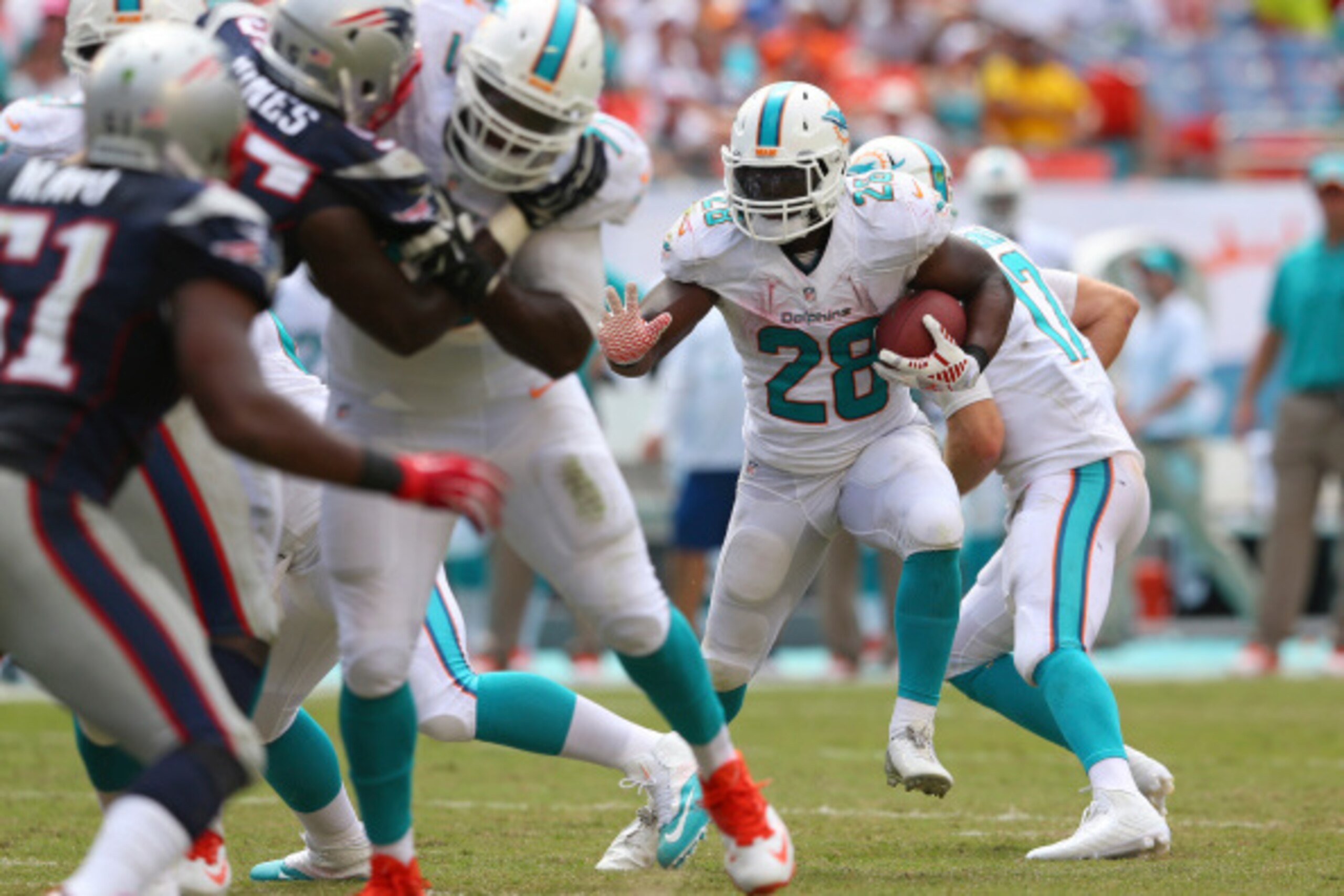 MIAMI GARDENS, FL - SEPTEMBER 07:  Knowshon Moreno #28 of the Miami Dolphins runs for yardage in the second half against the New England Patriots at Sun Life Stadium on September 7, 2014 in Miami Gardens, Florida.  (Photo by Mike Ehrmann/Getty Images)