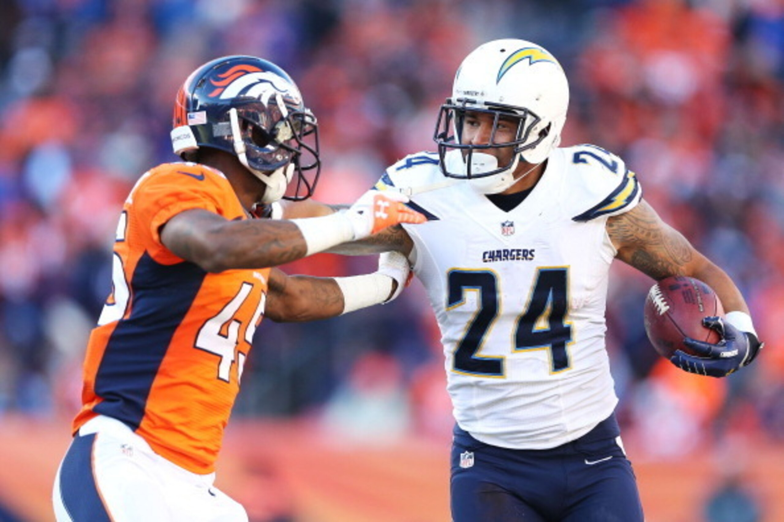 DENVER, CO - JANUARY 12:  Ryan Mathews #24 of the San Diego Chargers tries to avoid the tackle of  Dominique Rodgers-Cromartie #45 of the Denver Broncos during the AFC Divisional Playoff Game at Sports Authority Field at Mile High on January 12, 2014 in D