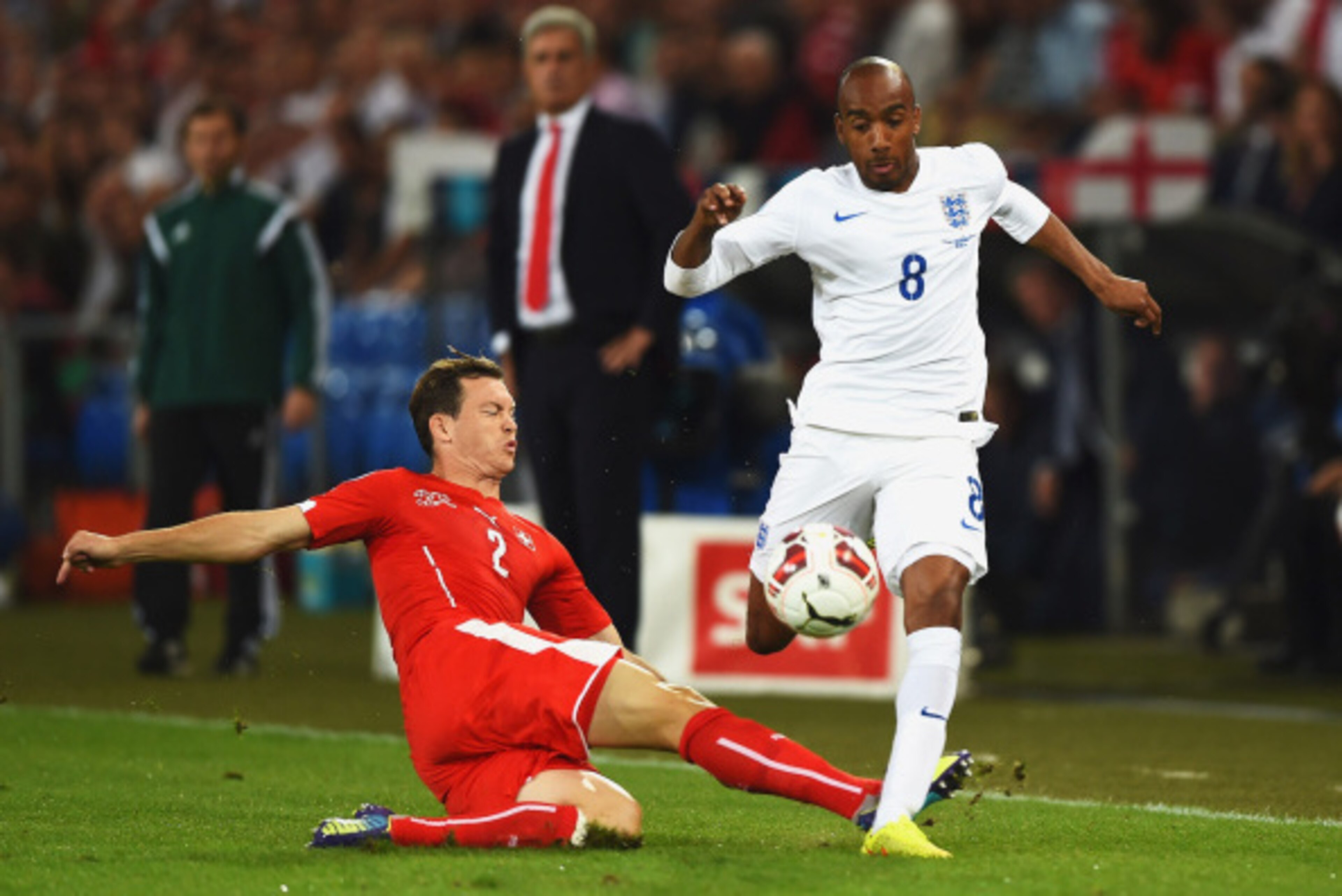BASEL, SWITZERLAND - SEPTEMBER 08:  Fabian Delph of England is tackled by Stephan Lichtsteiner of Switzerland during the UEFA EURO 2016 Group E qualifying match between Switzerland and England at St Jakob-Park on September 8, 2014 in Basel, Switzerland.  