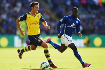 LEICESTER, ENGLAND - AUGUST 31:  Mesut Oezil of Arsenal is closed down by Jeffrey Schlupp of Leicester City during the Barclays Premier League match between Leicester City and Arsenal at The King Power Stadium on August 31, 2014 in Leicester, England.  (P