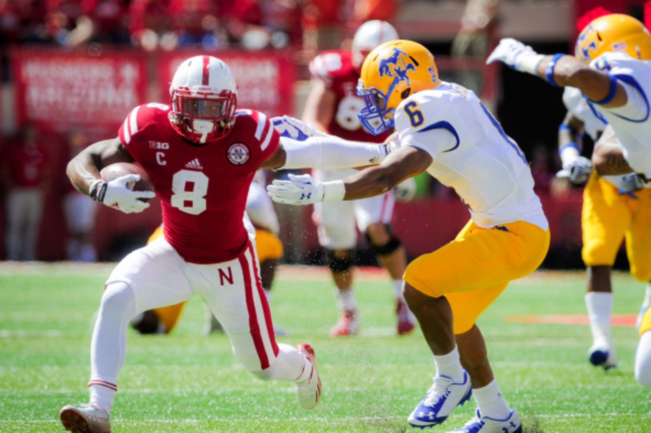 LINCOLN, NE - SEPTEMPER 6: Running back Ameer Abdullah #8 of the Nebraska Cornhuskers tries to get past defensive back Brent Spikes #6 of the McNeese State Cowboys during their game at Memorial Stadium on September 6, 2014 in Lincoln, Nebraska. (Photo by
