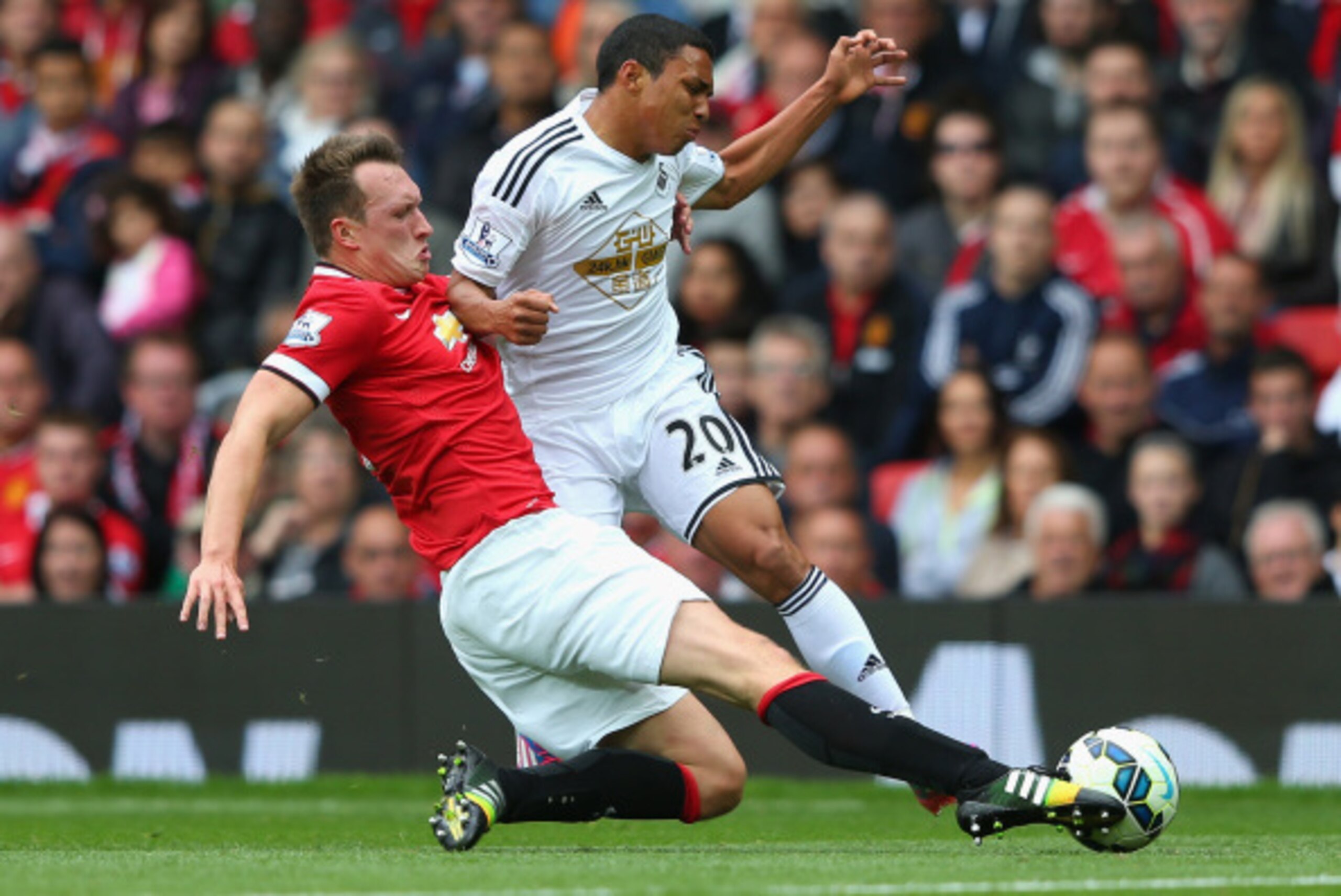MANCHESTER, ENGLAND - AUGUST 16:  Phil Jones of Manchester United tackles Jefferson Montero of Swansea City during the Barclays Premier League match between Manchester United and Swansea City at Old Trafford on August 16, 2014 in Manchester, England.  (Ph