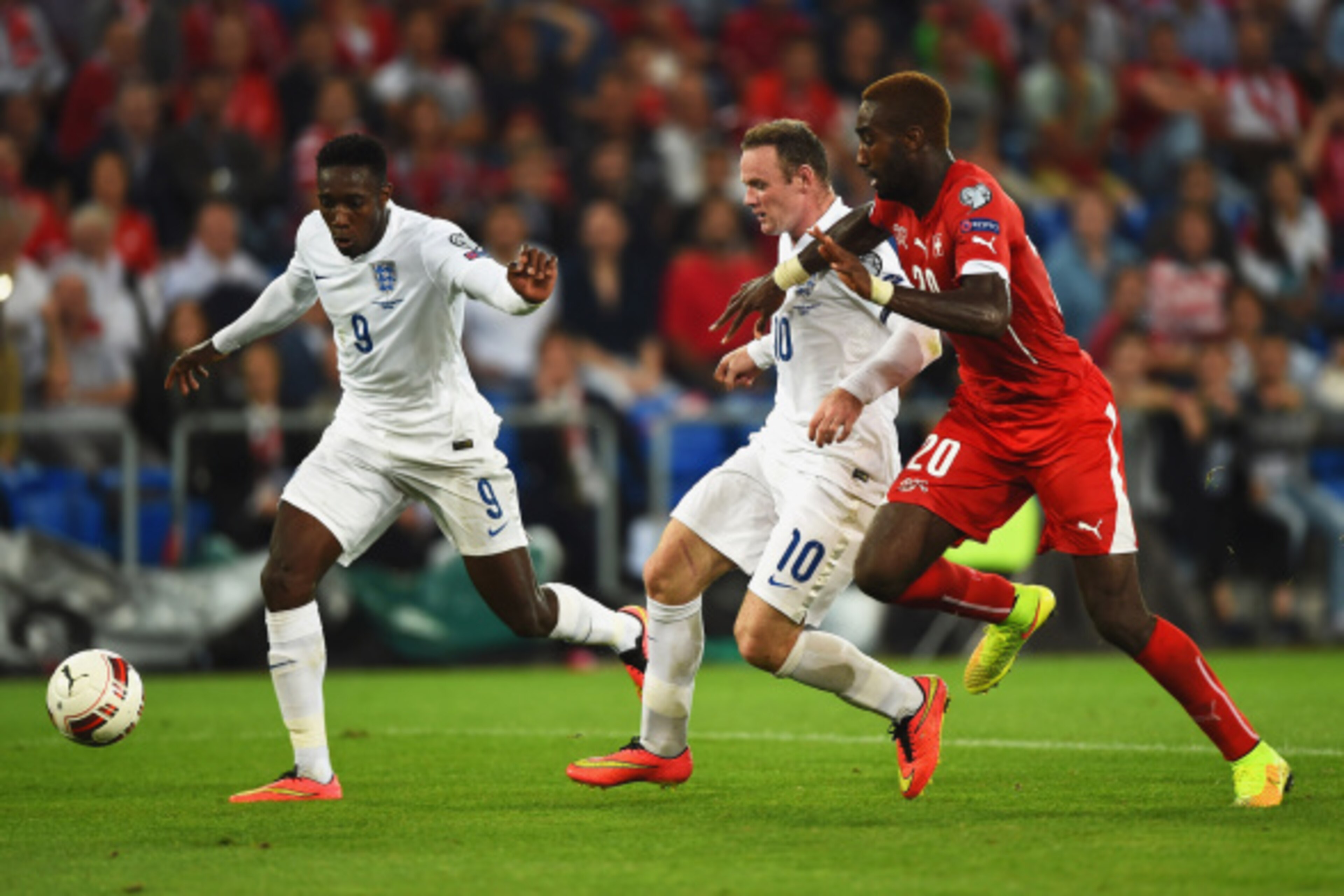 BASEL, SWITZERLAND - SEPTEMBER 08:  Danny Welbeck (9) and Wayne Rooney of England (10) battle with Johan Djourou of Switzerland during the UEFA EURO 2016 Group E qualifying match between Switzerland and England at St Jakob-Park on September 8, 2014 in Bas