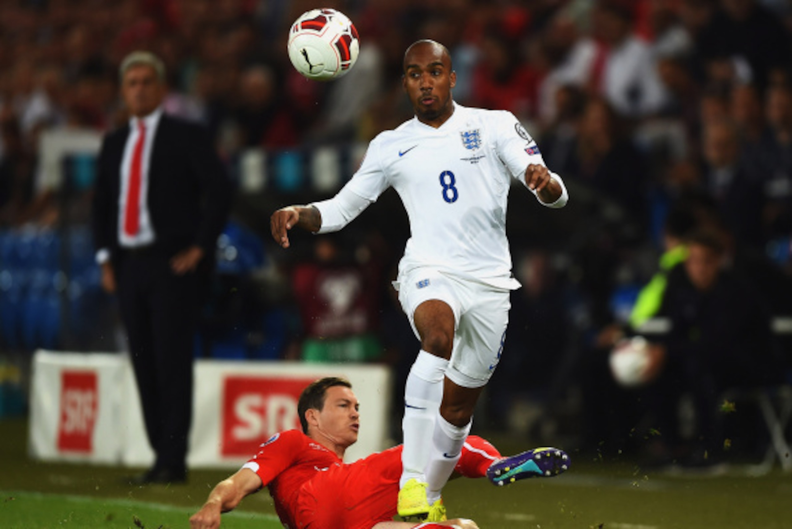 BASEL, SWITZERLAND - SEPTEMBER 08:  Fabian Delph of England is tackled by Stephan Lichtsteiner of Switzerland during the UEFA EURO 2016 Group E qualifying match between Switzerland and England at St Jakob-Park on September 8, 2014 in Basel, Switzerland.  