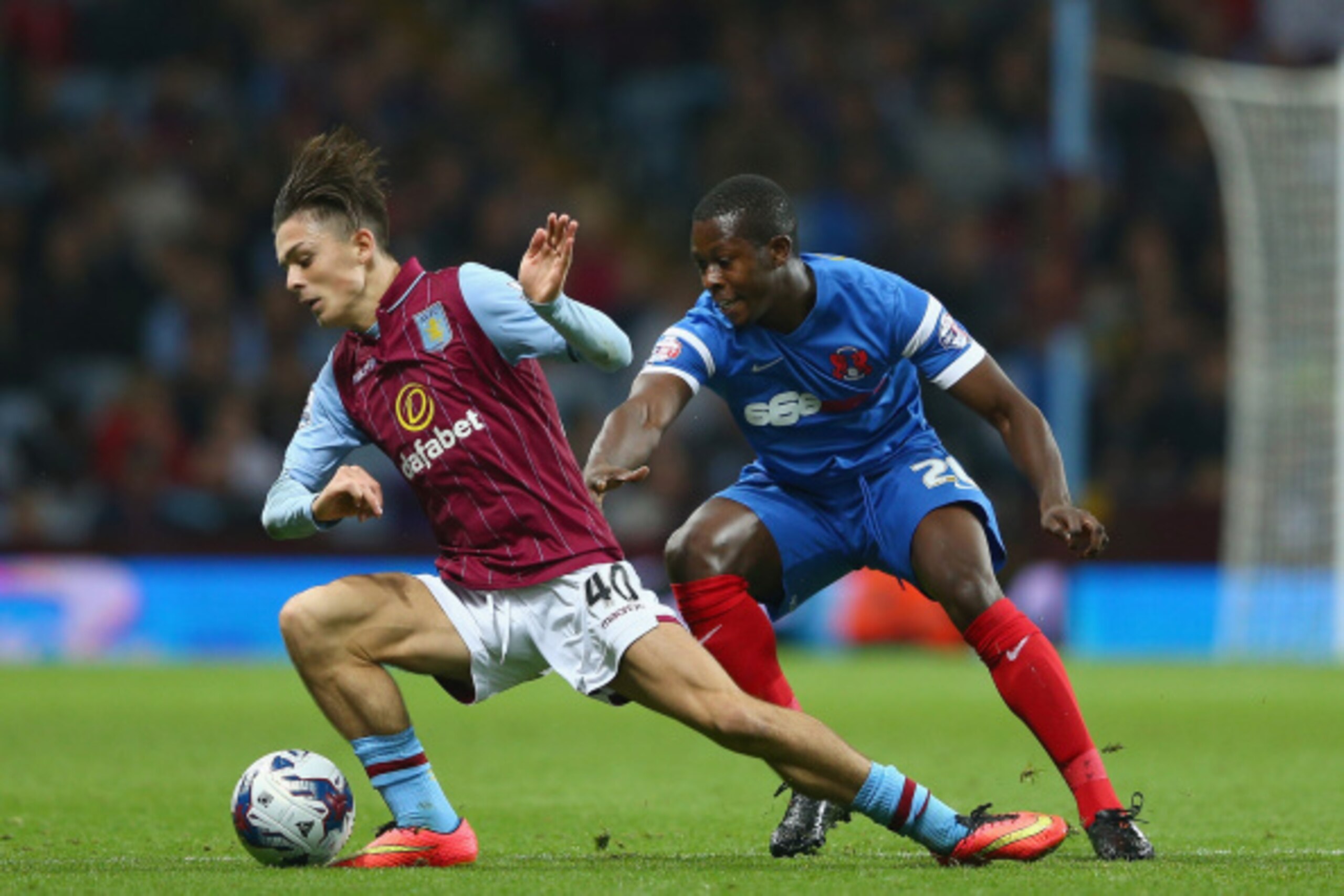 BIRMINGHAM, ENGLAND - AUGUST 27:  Jack Grealish of Aston Villa holds off a challenge from Marvin Bartley of Leyton Orient during the Capital One Cup second round match between Aston Villa and Leyton Orient at Villa Park on August 27, 2014 in Birmingham, E