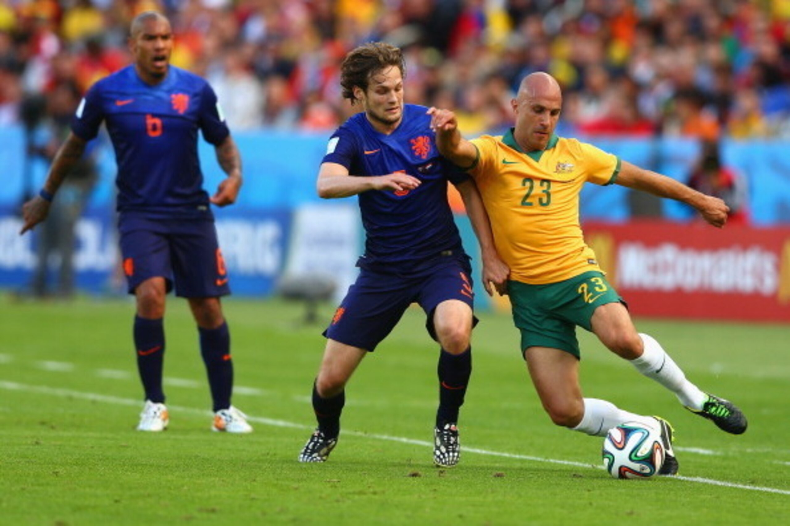 PORTO ALEGRE, BRAZIL - JUNE 18:  Daley Blind of the Netherlands and Mark Bresciano of Australia compete for the ball  during the 2014 FIFA World Cup Brazil Group B match between Australia and Netherlands at Estadio Beira-Rio on June 18, 2014 in Porto Aleg