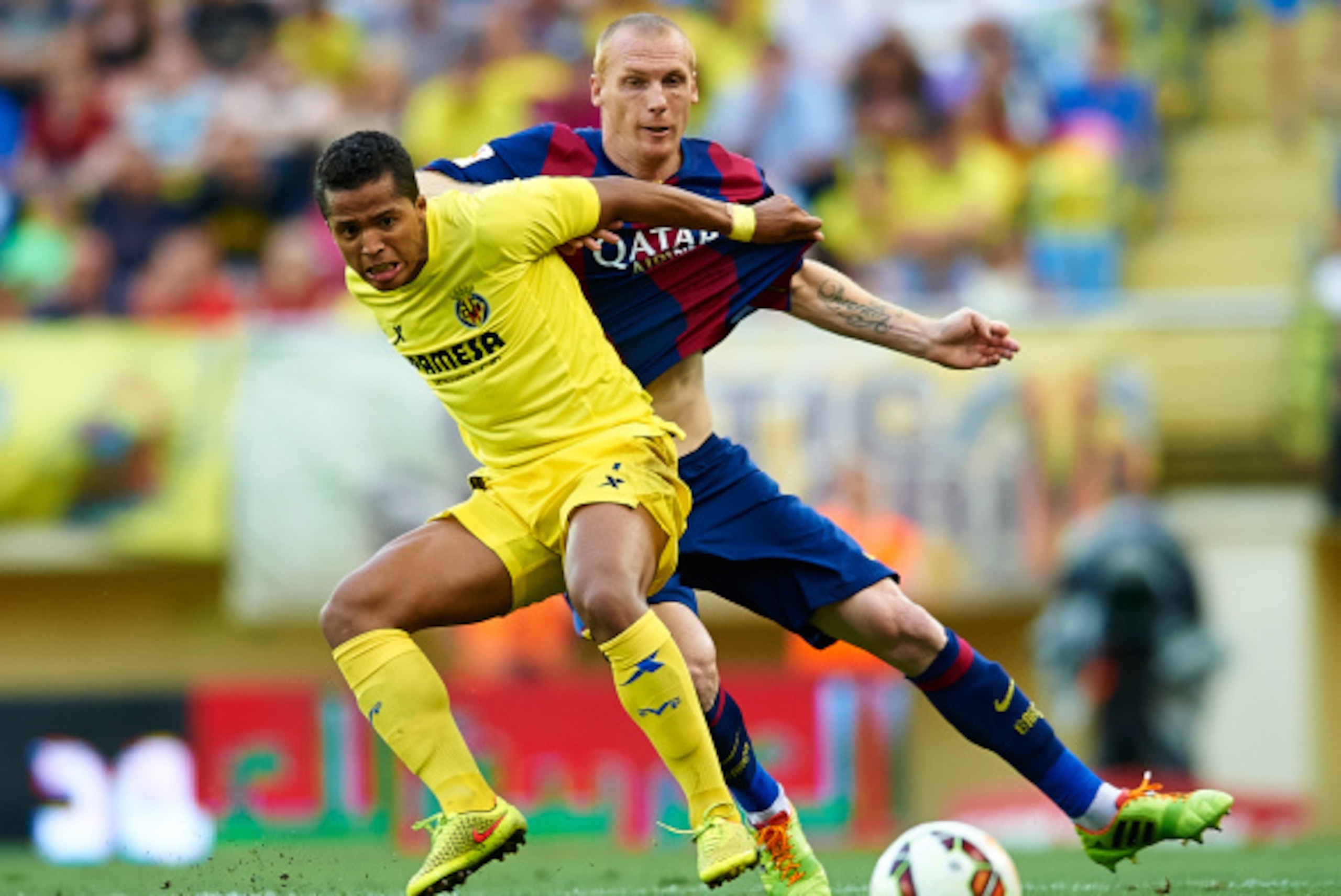 VILLARREAL, SPAIN - AUGUST 31:  Giovani Dos Santos (L) of Villarreal competes for the ball with Mathieu of Barcelona during the La Liga match between Villarreal CF and FC Barcelona at El Madrigal stadium on August 31, 2014 in Villarreal, Spain.  (Photo by