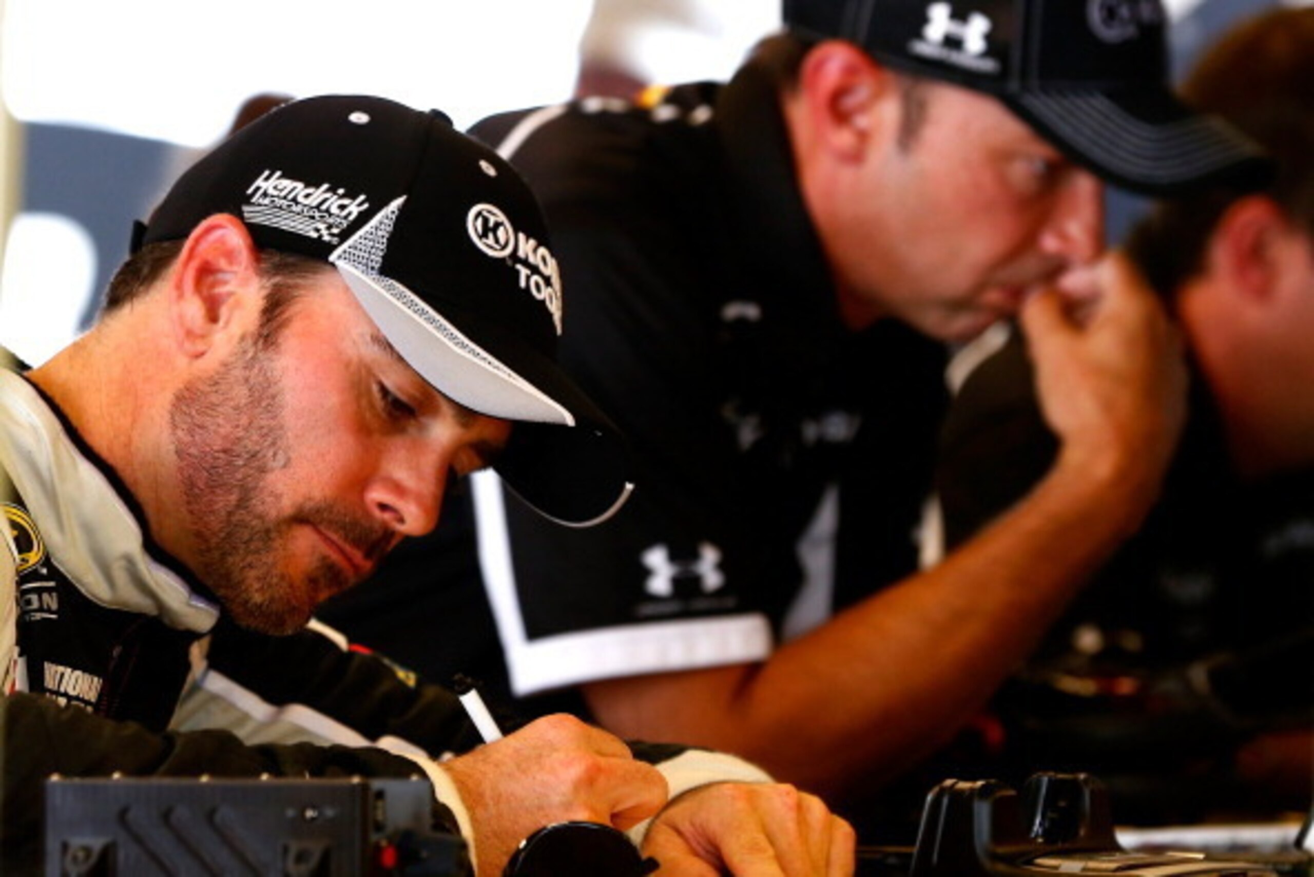 INDIANAPOLIS, IN - JULY 26:  Jimmie Johnson, driver of the #48 Lowe's / Kobalt Tools Chevrolet, and crew chief Chad Knaus look on in the garage area during practice for the NASCAR Sprint Cup Series Crown Royal Presents The John Wayne Walding 400 at the Br