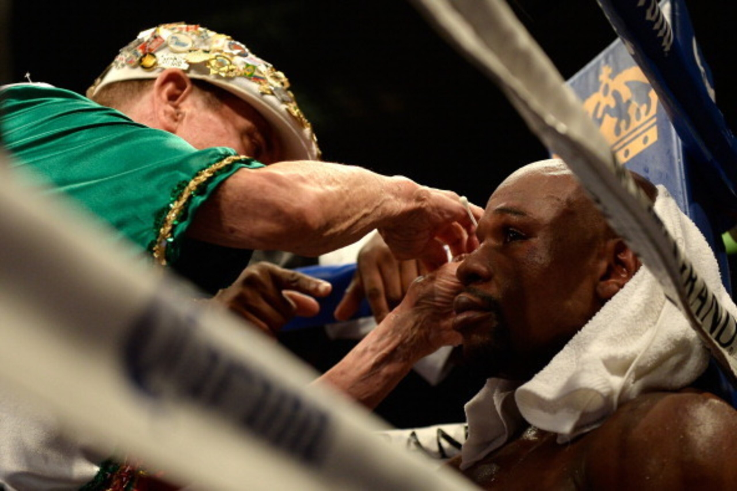 LAS VEGAS, NV - MAY 03:  Cut man Rafael Garcia works on a cut above Floyd Mayweather Jr.'s left eye during a break in a round against Marcos Maidana during their WBC/WBA welterweight unification fight at the MGM Grand Garden Arena on May 3, 2014 in Las Ve