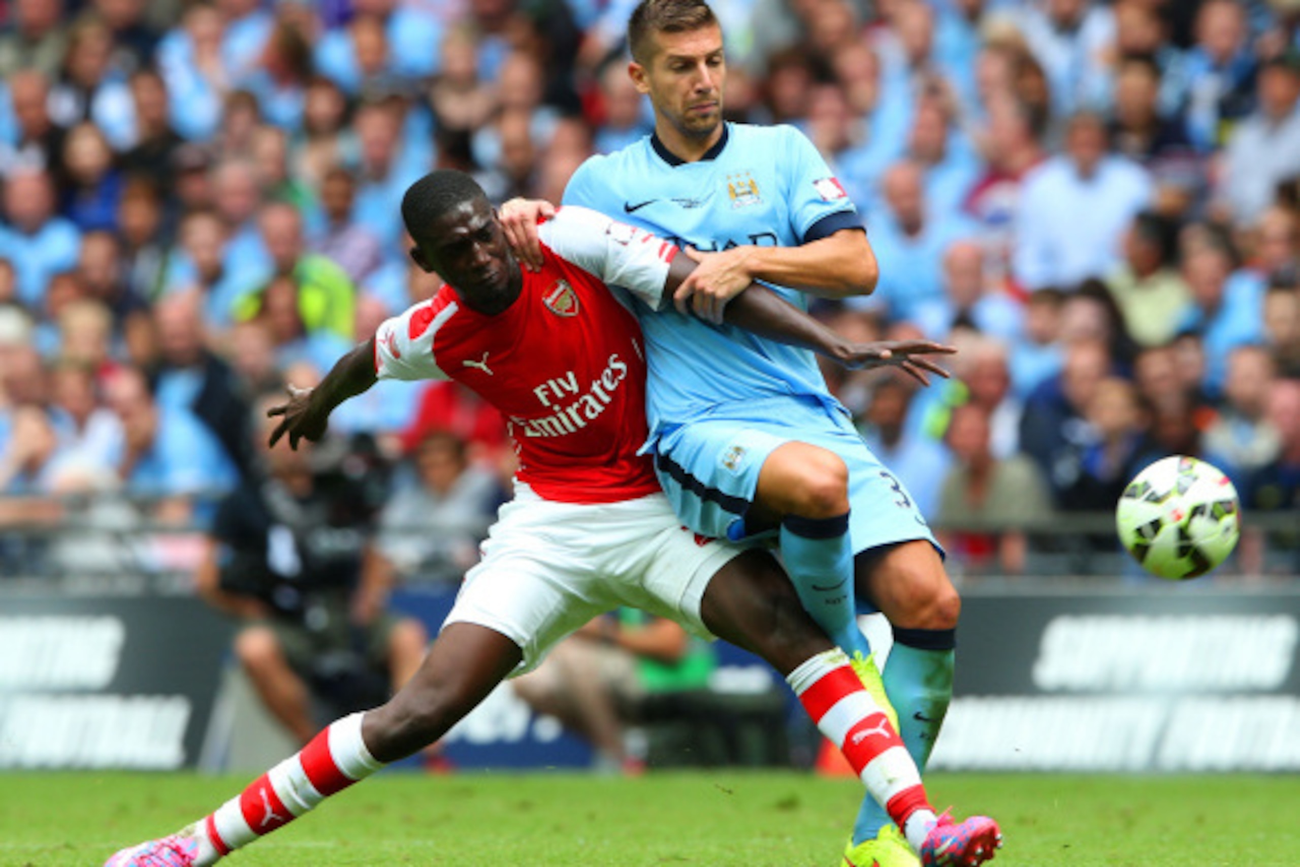 LONDON, ENGLAND - AUGUST 10: Yaya Sanogo of Arsenal challenges Matija Nastasic of Manchester City during the FA Community Shield match between Manchester City and Arsenal at Wembley Stadium on August 10, 2014 in London, England.  (Photo by David Rogers/Ge