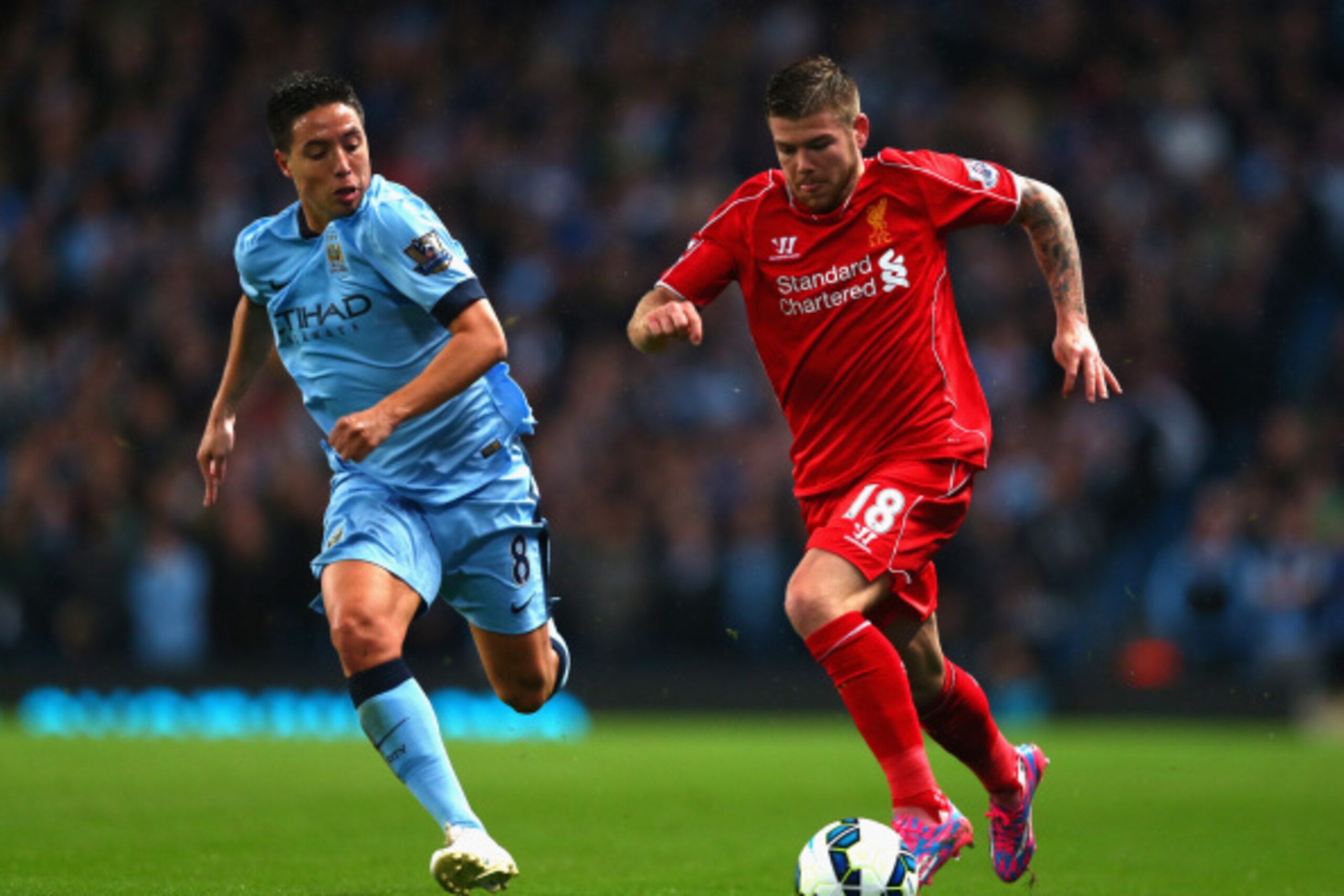 MANCHESTER, ENGLAND - AUGUST 25:   Alberto Moreno of Liverpool competes with Samir Nasri of Manchester City during the Barclays Premier League match between Manchester City and Liverpool at the Etihad Stadium on August 25, 2014 in Manchester, England.  (P