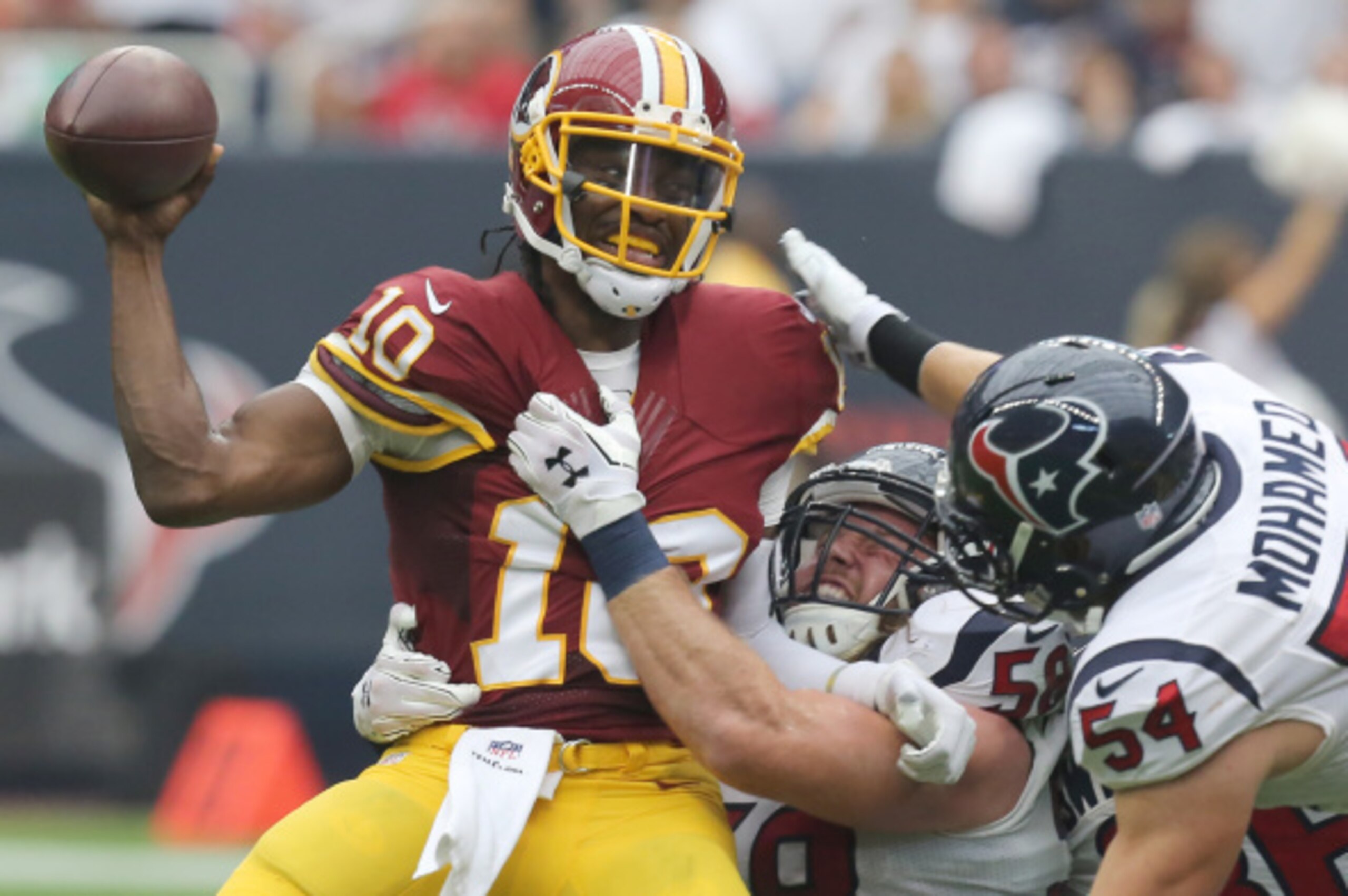 HOUSTON, TX- SEPTEMBER 07: Washington Redskins quarterback Robert Griffin III #10 is sacked by Houston Texans linebacker Brooks Reed #58 and linebacker Mike Mohamed #54 in the second quarter on September 7, 2014 at NRG Stadium in Houston, Texas. (Photo by