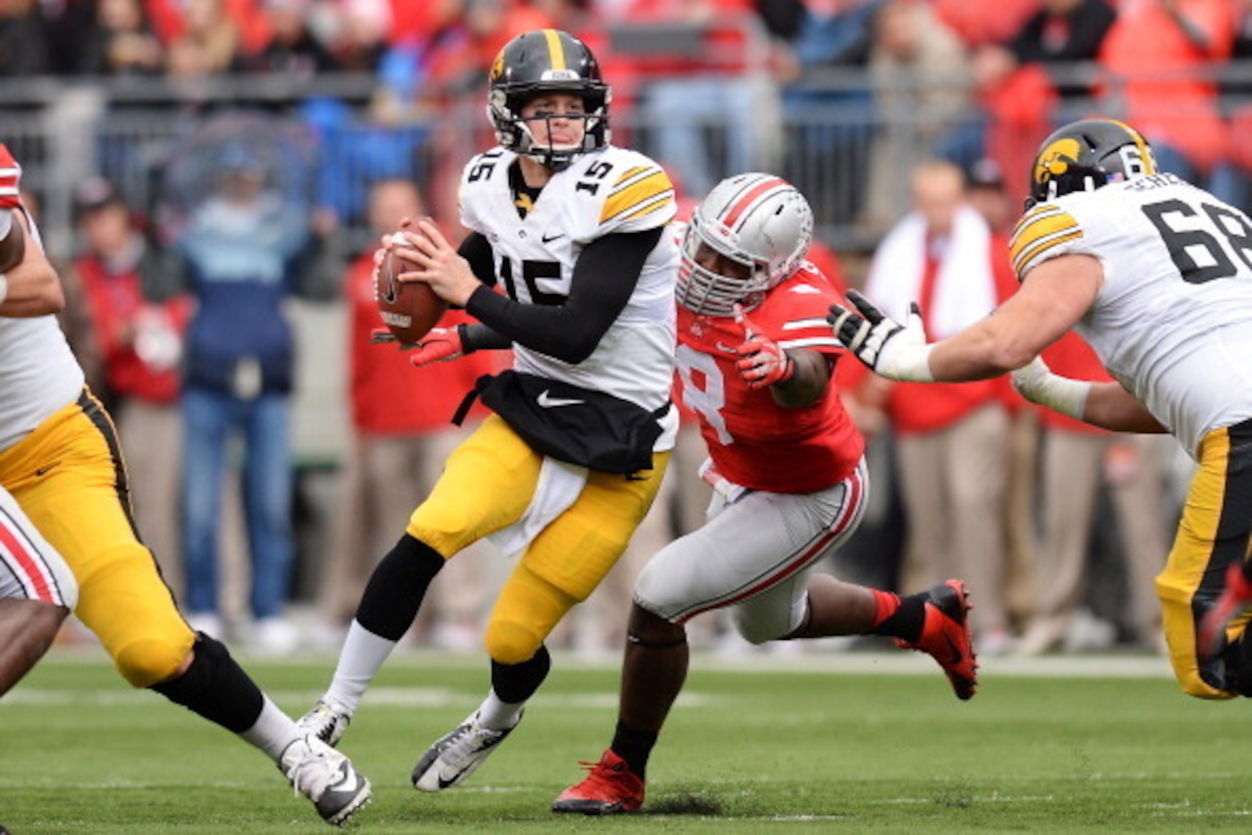 COLUMBUS, OH - OCTOBER 19:  Noah Spence #8 of the Ohio State Buckeyes forces quarterback Jake Rudock #15 of the Iowa Hawkeyes out of the pocket in the second quarter at Ohio Stadium on October 19, 2013 in Columbus, Ohio.  (Photo by Jamie Sabau/Getty Image