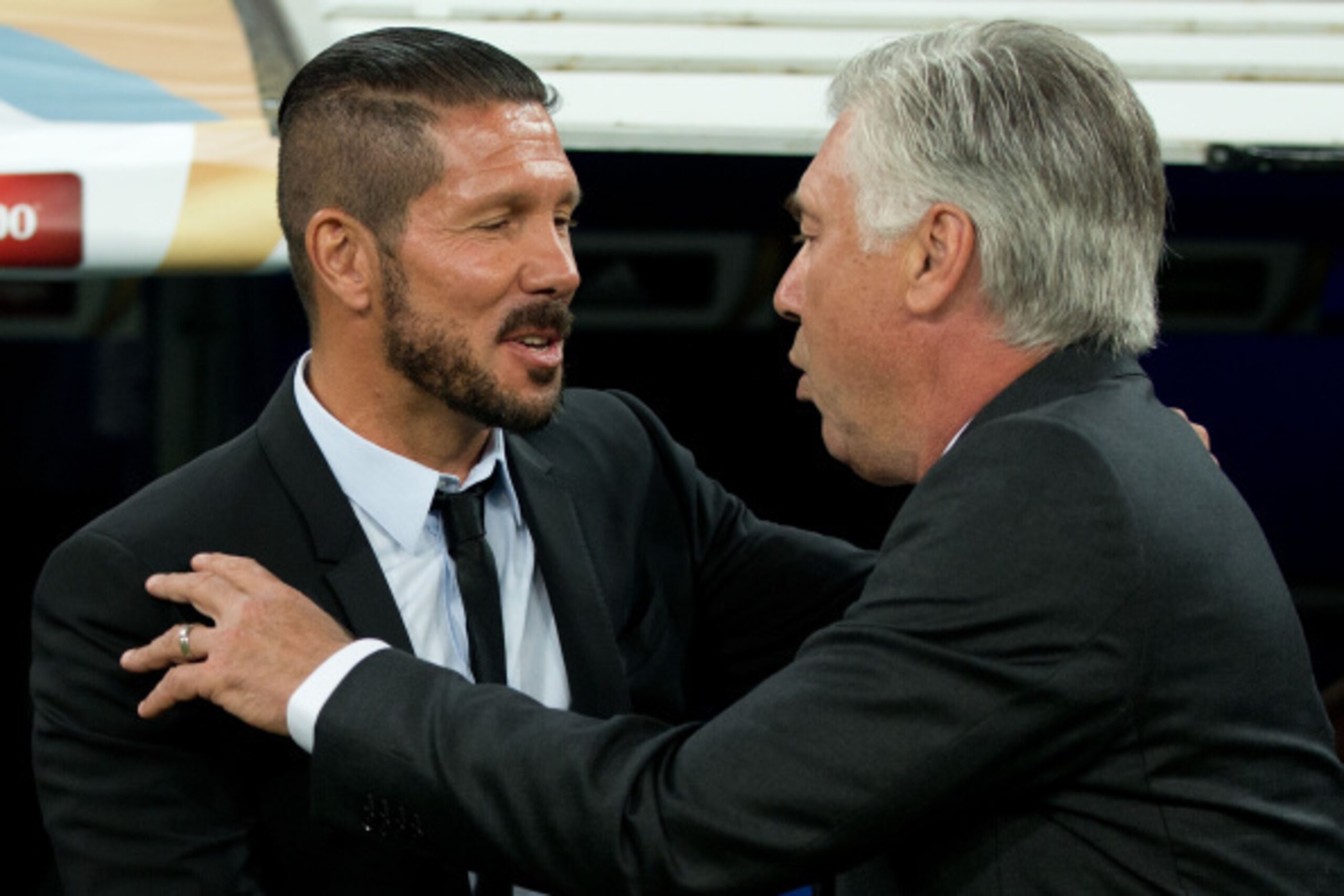 MADRID, SPAIN - AUGUST 19: head coach Diego Pablo Simeone (L) of Atletico de Madrid is greeted by head coach Carlo Ancelotti (R) of Real Madrid CF prior to start the Supercopa first leg match between Real Madrid and Club Atletico de Madrid at Estadio Sant