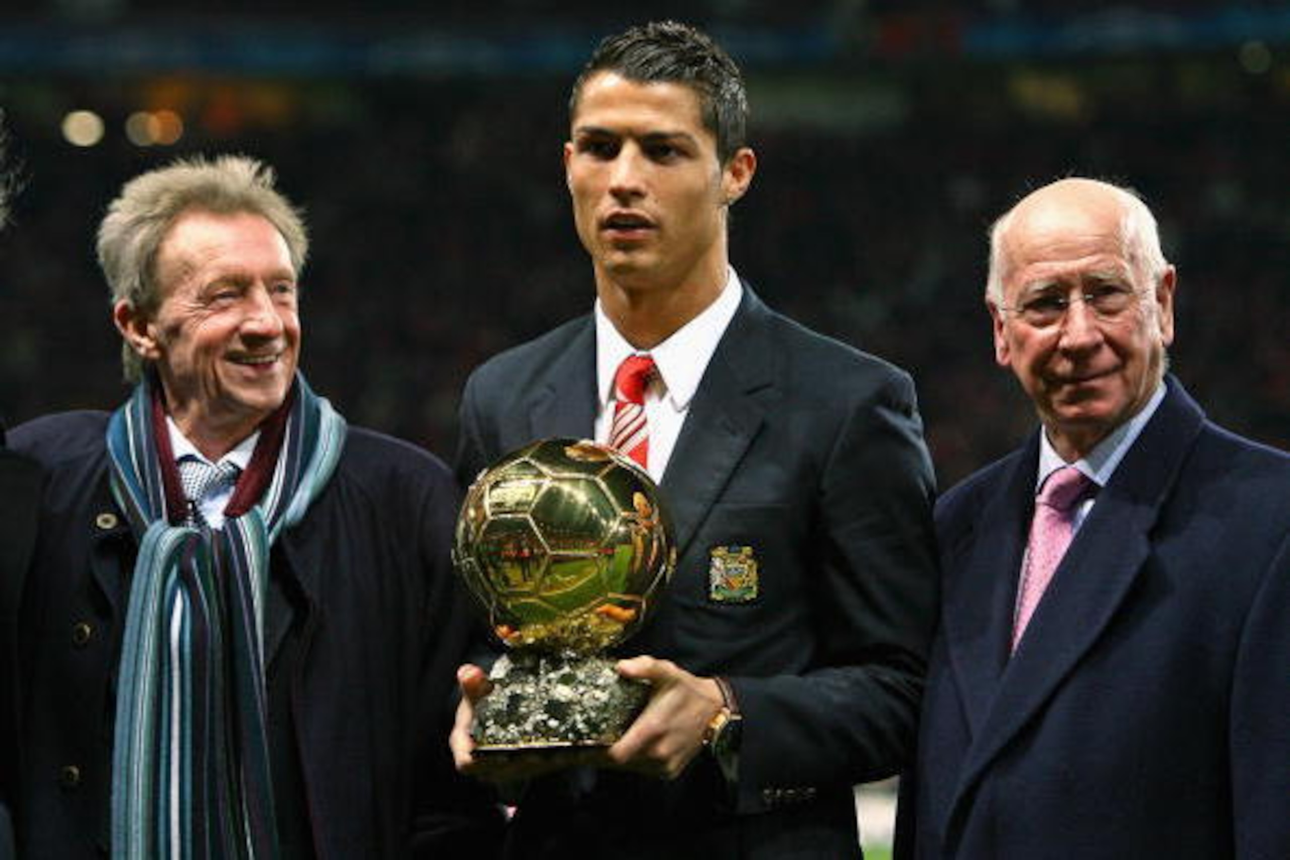 MANCHESTER, UNITED KINGDOM - DECEMBER 10:  Cristiano Ronaldo (C) of Manchester United receives the Ballon d'or as the European Footballer of the Year flanked by previous winners Denis Law (L) and Bobby Charlton before the UEFA Champions League Group E mat