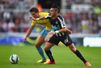 NEWCASTLE UPON TYNE, ENGLAND - AUGUST 30:  Martin Kelly of Crystal Palace and Remy Cabella of Newcastle United battle for the ball during the Barclays Premier League match between Newcastle United and Crystal Palace at St James' Park on August 30, 2014 in