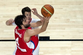 MADRID, SPAIN - SEPTEMBER 12: Milos Teodosic (L) of Serbia shoots against Thomas Heurtel (R) of France during the 2014 FIBA World Basketball Championship semifinal match between France and Serbia at Palacio de los Deportes on September 12, 2014 in Madrid,