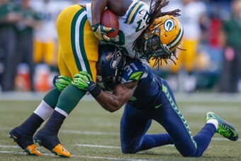 SEATTLE, WA - SEPTEMBER 04:  Running back Eddie Lacy #27 of the Green Bay Packers is tackled by strong safety Kam Chancellor #31 of the Seattle Seahawks in the second quarter at CenturyLink Field on September 4, 2014 in Seattle, Washington.  (Photo by Ott