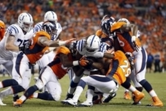 Sep 7, 2014; Denver, CO, USA; Indianapolis Colts running back Trent Richardson (34) is tackled during the second half against the Denver Broncos at Sports Authority Field at Mile High. Mandatory Credit: Chris Humphreys-USA TODAY Sports