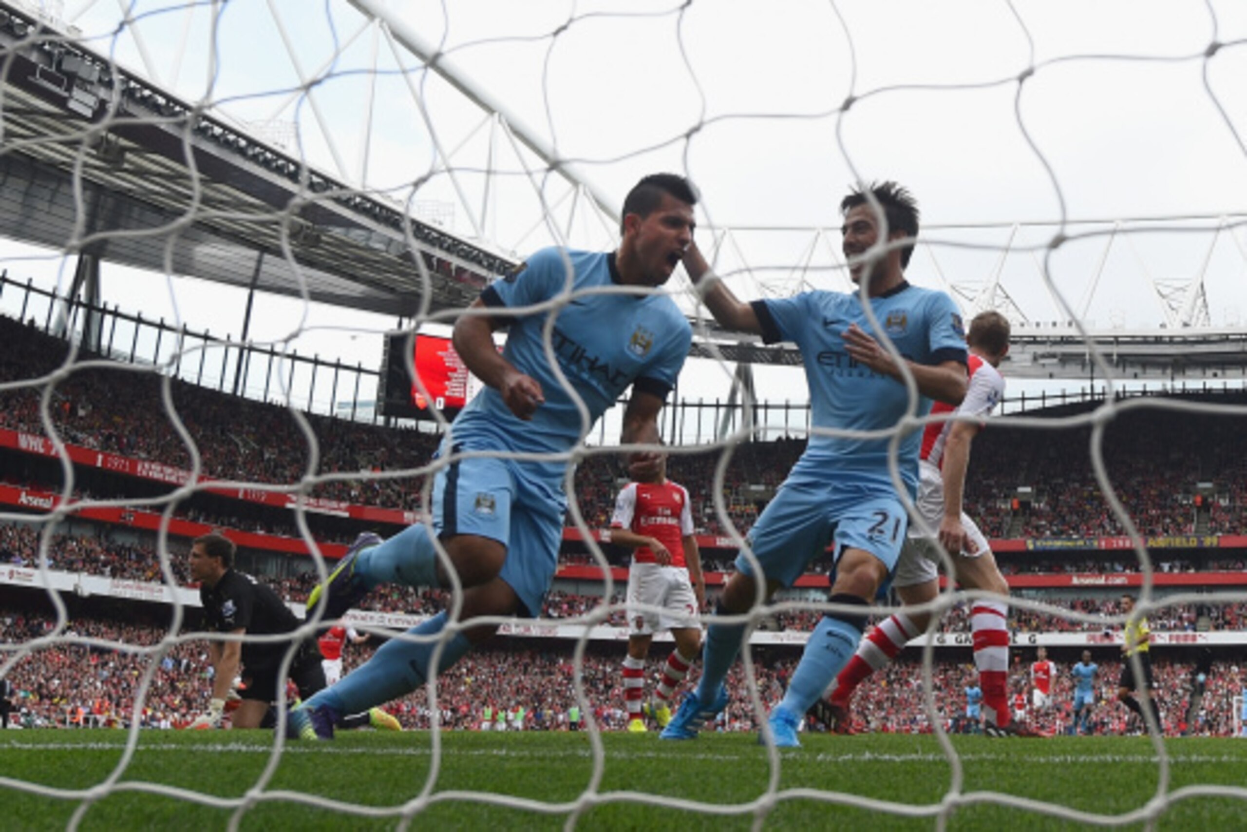LONDON, ENGLAND - SEPTEMBER 13:  Sergio Aguero of Manchester City celebrates with team-mate David Silva after scoring the first goal during the Barclays Premier League match between Arsenal and Manchester City at Emirates Stadium on September 13, 2014 in 