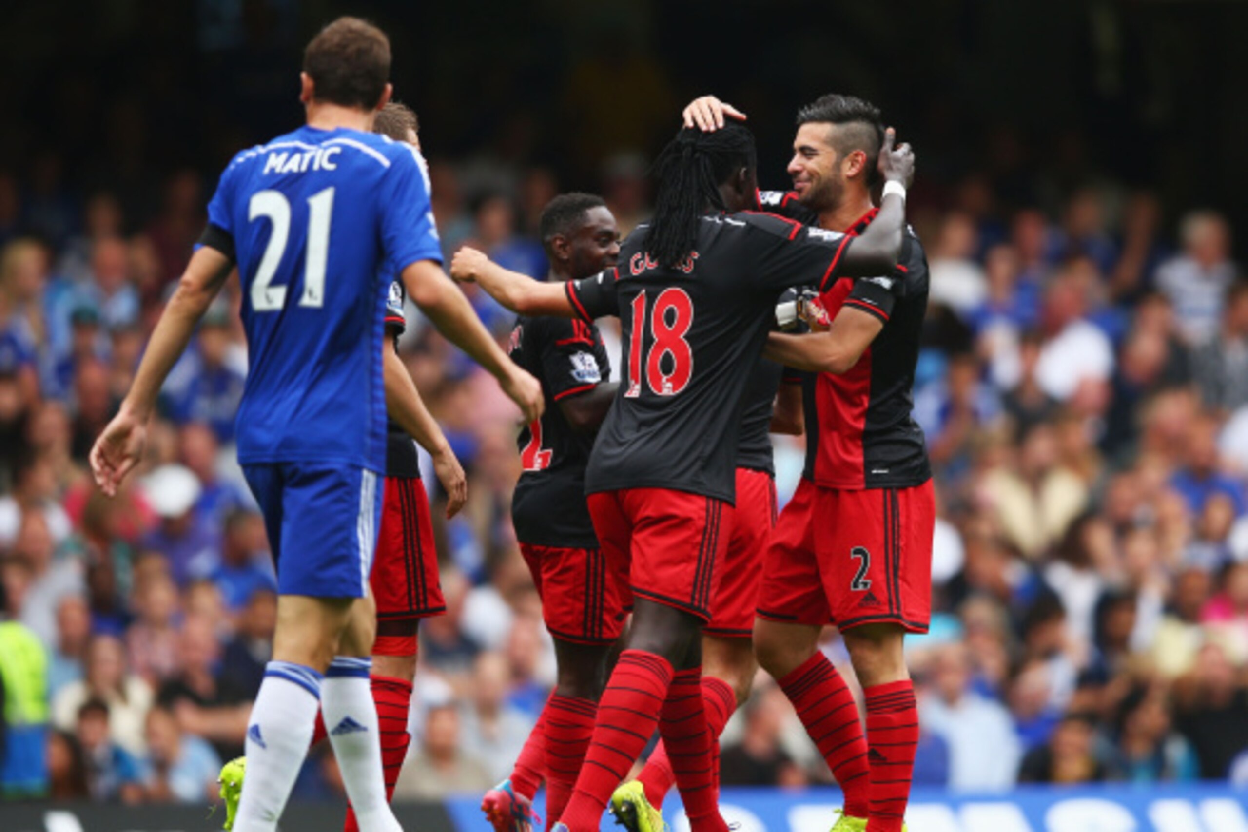 LONDON, ENGLAND - SEPTEMBER 13:  Bafetibis Gomis (18) and Jordi Amat of Swansea City (2) celebrate as John Terry of Chelsea (not pictured) scores an own goal for their first goal during the Barclays Premier League match between Chelsea and Swansea City at