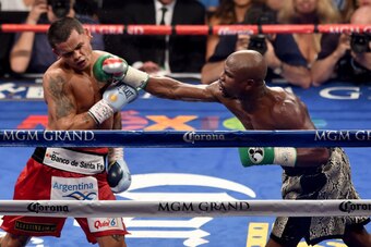 LAS VEGAS, NV - SEPTEMBER 13:  (R-L) Floyd Mayweather Jr. throws a right to the face of Marcos Maidana during their WBC/WBA welterweight title fight at the MGM Grand Garden Arena on September 13, 2014 in Las Vegas, Nevada.  (Photo by Ethan Miller/Getty Im