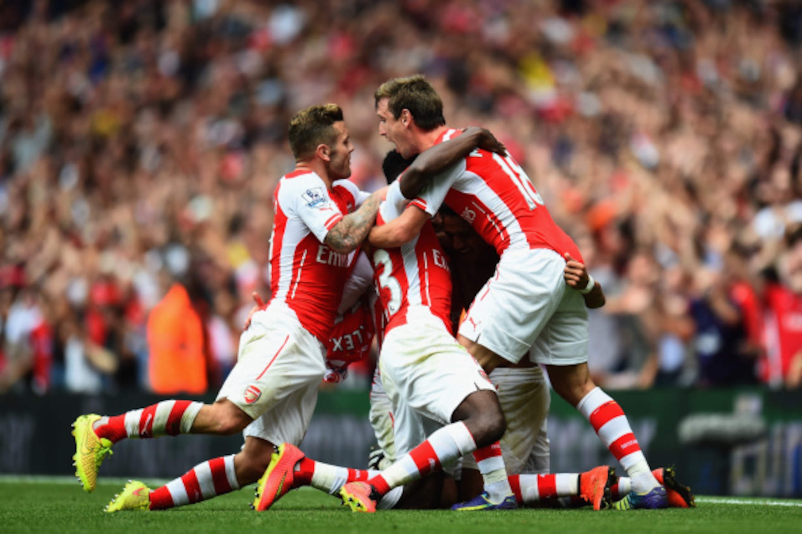 LONDON, ENGLAND - SEPTEMBER 13:  Alexis Sanchez of Arsenal is congratulated by team-mates after scoring during the Barclays Premier League match between Arsenal and Manchester City at Emirates Stadium on September 13, 2014 in London, England.  (Photo by S