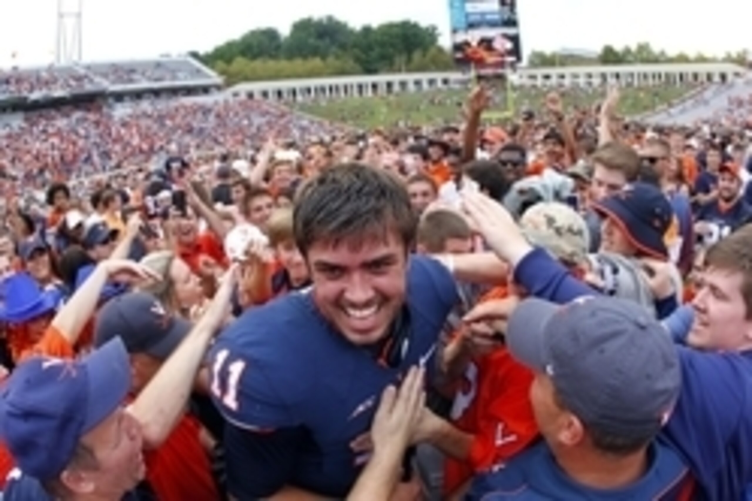 Sep 13, 2014; Charlottesville, VA, USA; Virginia Cavaliers quarterback Greyson Lambert (11) celebrates with fans on the field after the Cavaliers game against the Louisville Cardinals at Scott Stadium. The Cavaliers won 23-21. Mandatory Credit: Geoff Burk