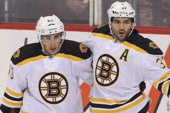 WINNIPEG, MB - SEPTEMBER 26: Patrice Bergeron #37 of the Boston Bruins is congratulated by teammate Brad Marchand #63 after his goal against Ondrej Pavelev #31 of the Winnipeg Jets in first period action during an NHL preseason game at the MTS Centre on S