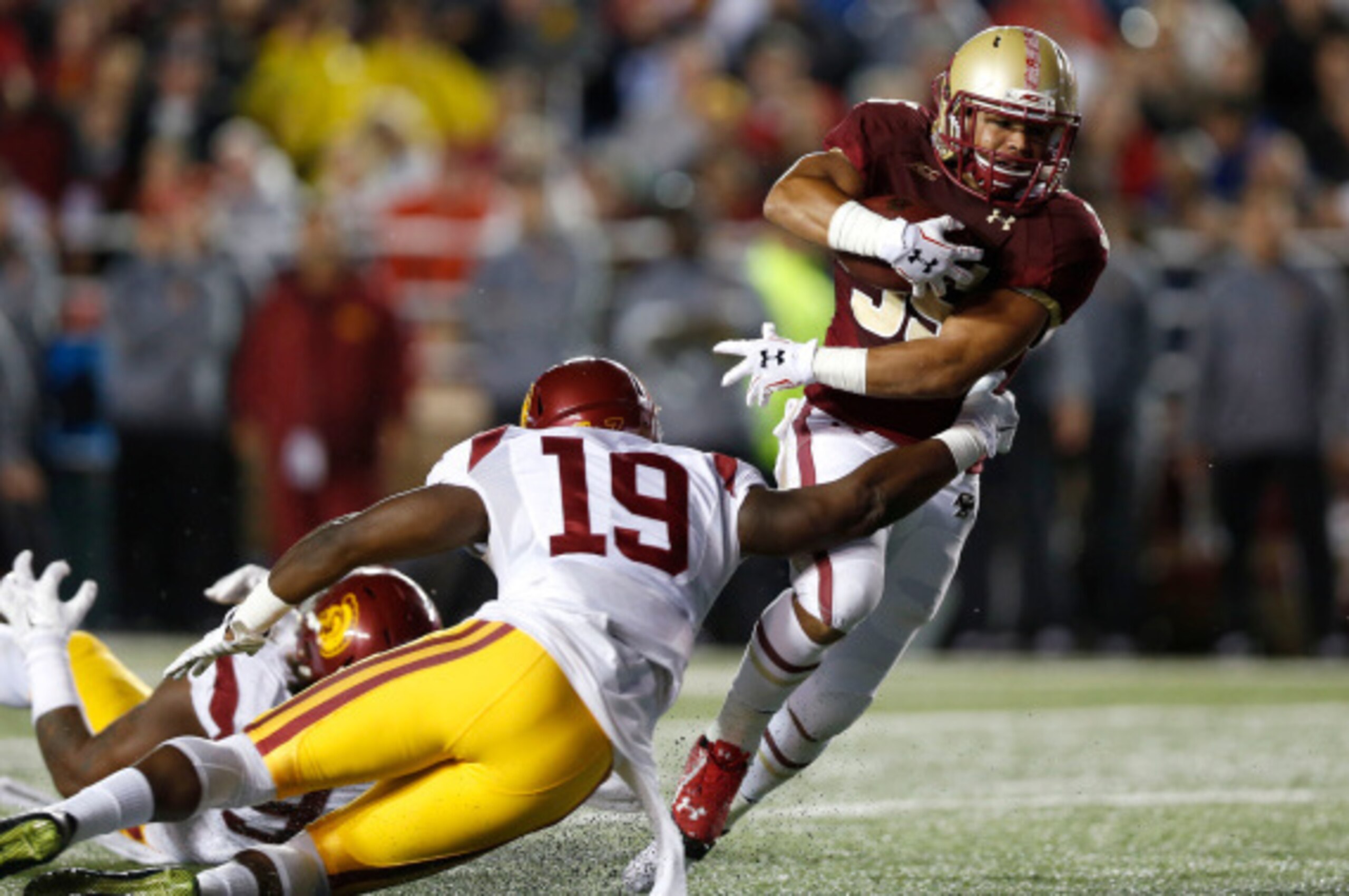 BOSTON, MA- SEPTEMBER 13:  Running back Tyler Rouse #35 of the Boston College Eagles tries to break away from linebacker Michael Hutchings #19 of the USC Trojans during the first half at Alumni Stadium on September 13 in Chestnut Hill, Massachusetts.  (Ph