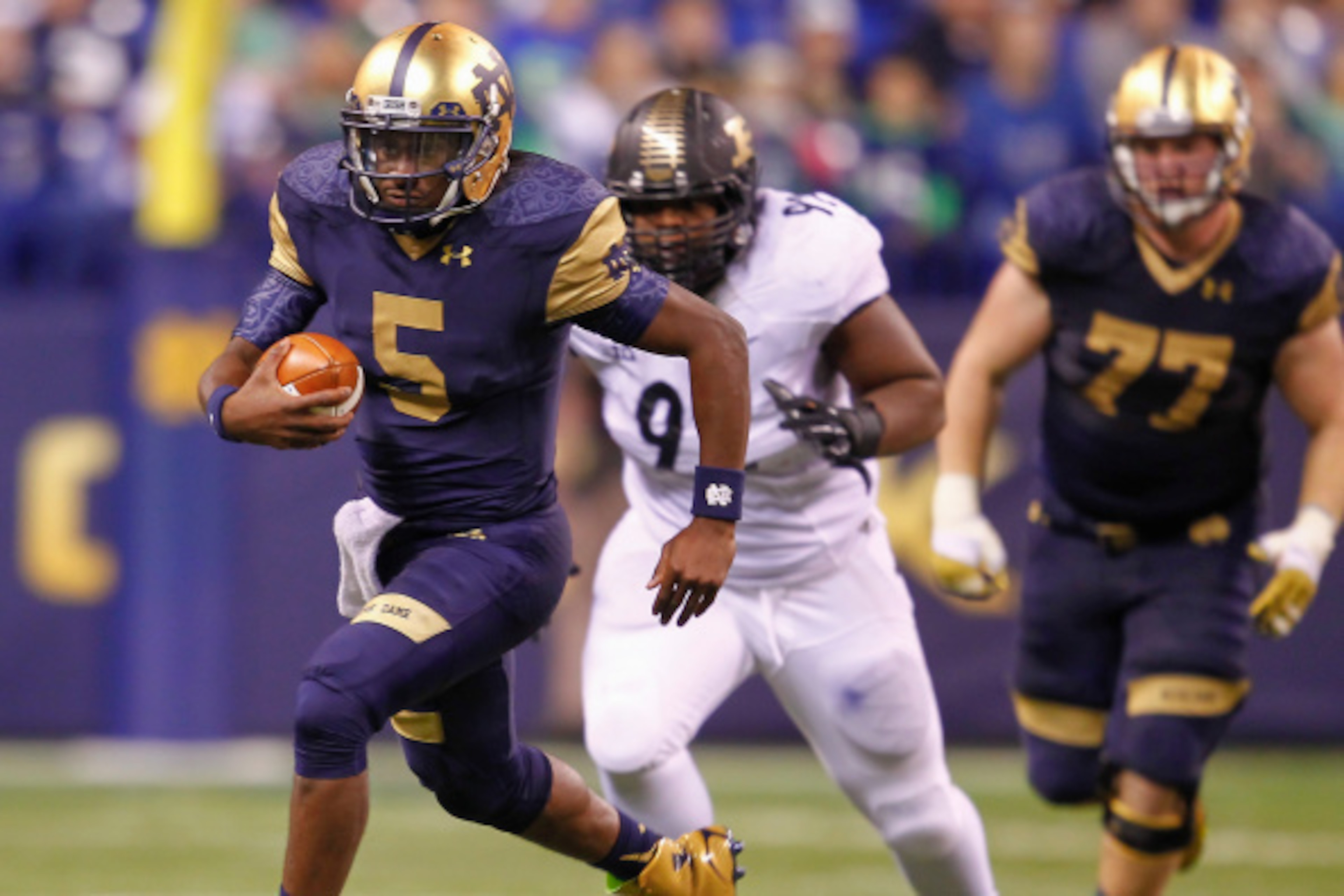 INDIANAPOLIS, IN - SEPTEMBER 13: Everett Golson #5 of the Notre Dame Fighting Irish runs the ball as Ryan Watson #92 of the Purdue Boilermakers trails behind at Lucas Oil Stadium on September 13, 2014 in Indianapolis, Indiana.  Notre Dame defeated Purdue 