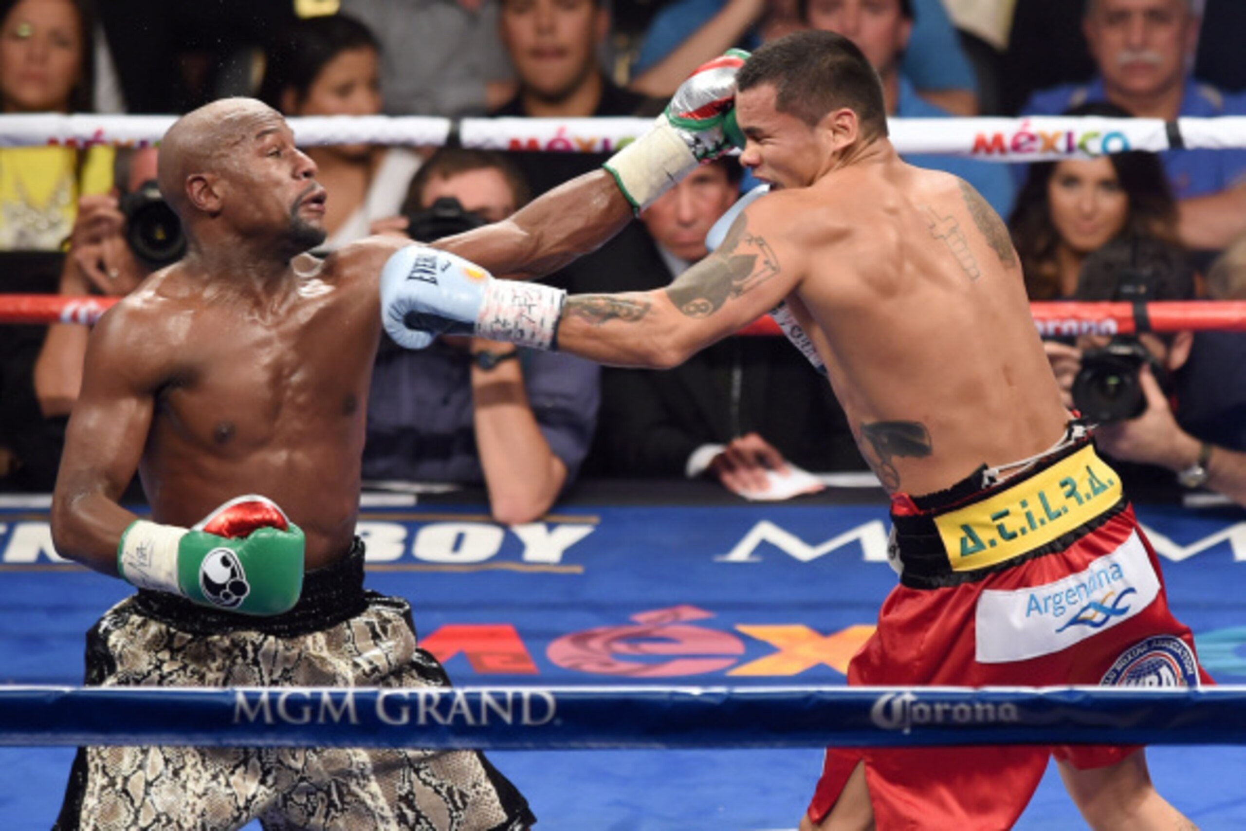 LAS VEGAS, NV - SEPTEMBER 13:  Floyd Mayweather Jr. (L) hits Marcos Maidana with a left in the fourth round of their WBC/WBA welterweight title fight at the MGM Grand Garden Arena on September 13, 2014 in Las Vegas, Nevada. Mayweather Jr. won by unanimous