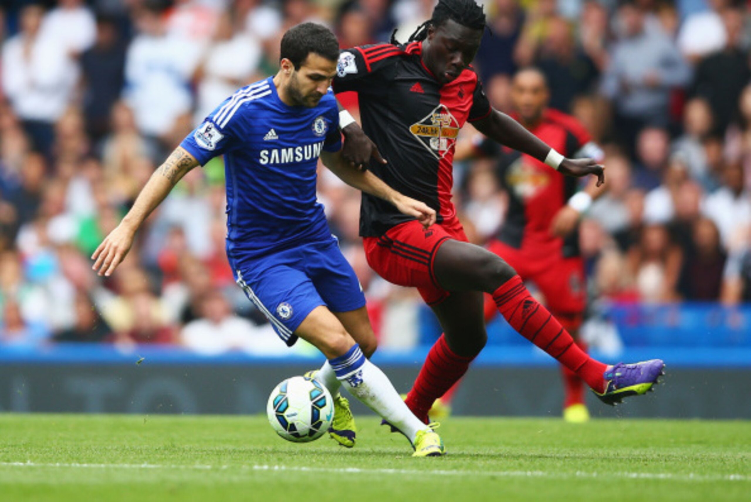 LONDON, ENGLAND - SEPTEMBER 13:  Cesc Fabregas of Chelsea holds off Bafetibis Gomis of Swansea City during the Barclays Premier League match between Chelsea and Swansea City at Stamford Bridge on September 13, 2014 in London, England.  (Photo by Paul Gilh