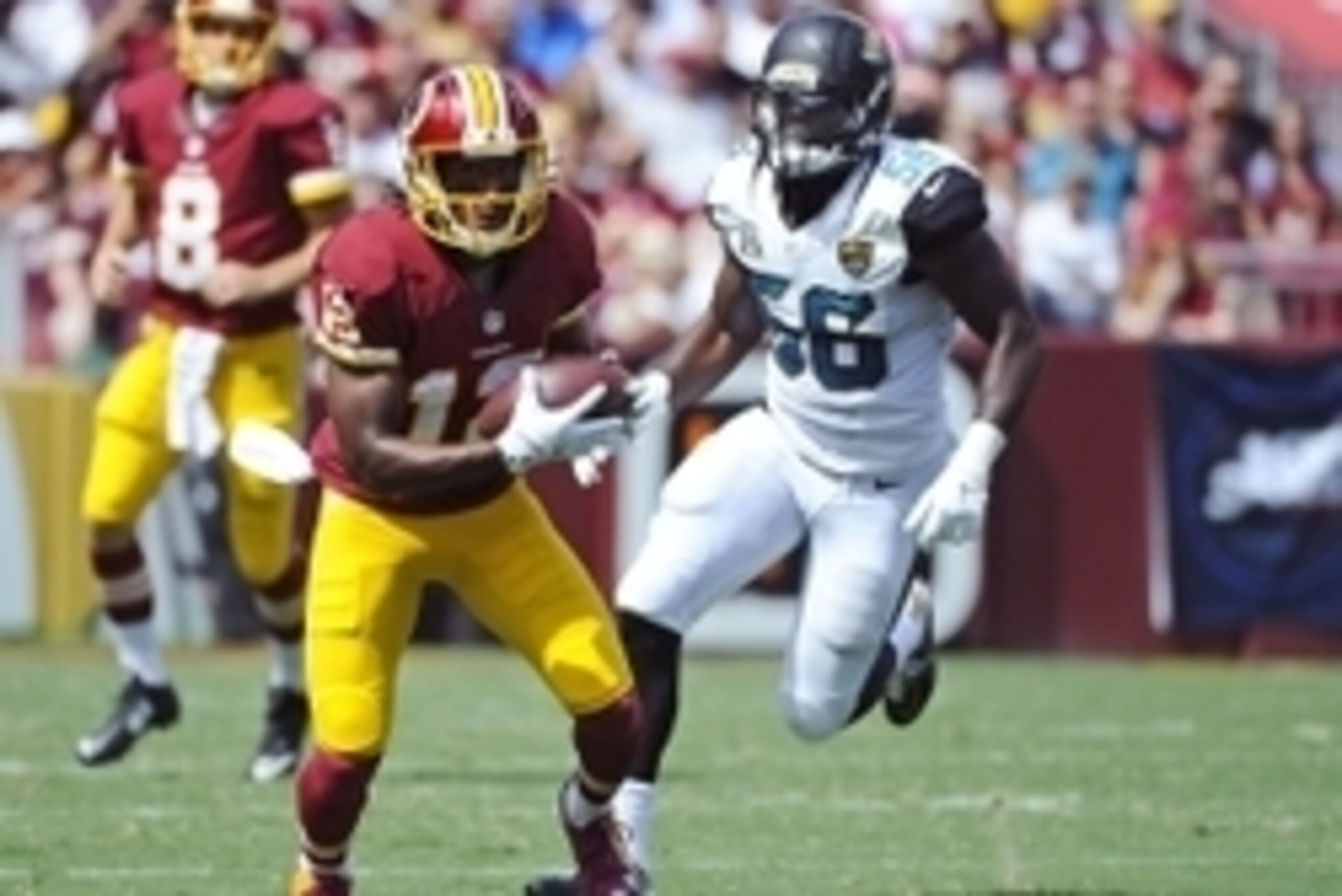 Sep 14, 2014; Landover, MD, USA; Washington Redskins wide receiver Andre Roberts (12) runs after a reception as Jacksonville Jaguars linebacker LaRoy Reynolds (56) defends during the first half at FedEx Field. Mandatory Credit: Brad Mills-USA TODAY Sports